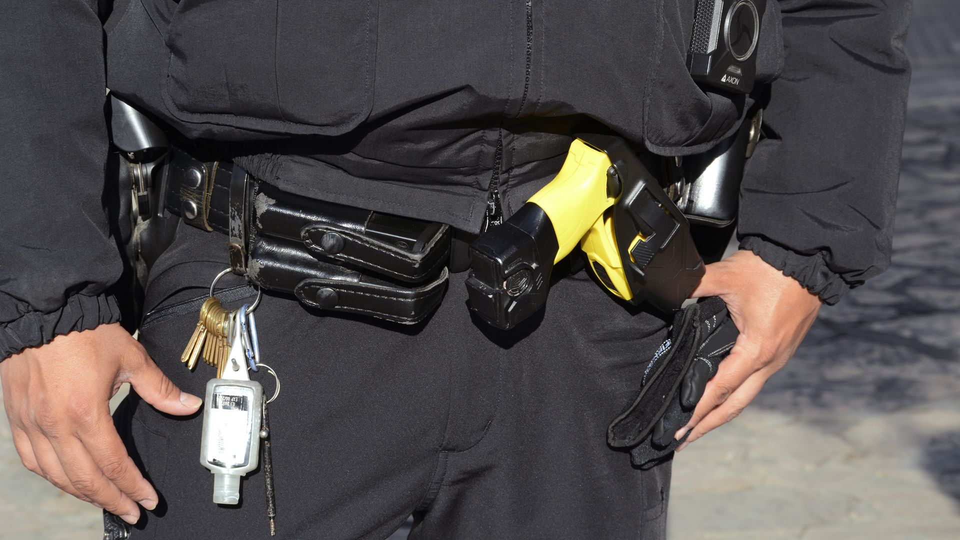 a yellow taser seen in an up close shot of a police officer's belt.