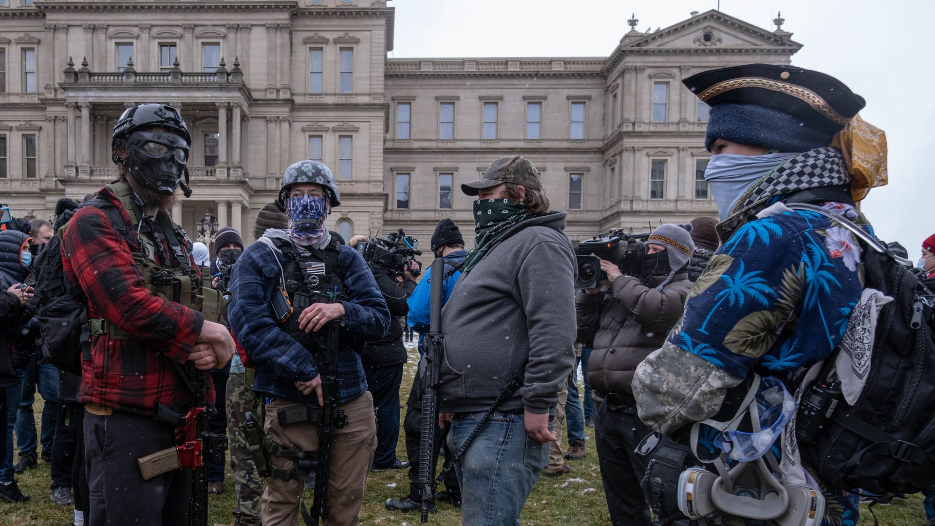 Members of the Michigan Boogaloo Bois an anti-government group stand with their long guns near the Capitol Building in Lansing, Michigan on January 17