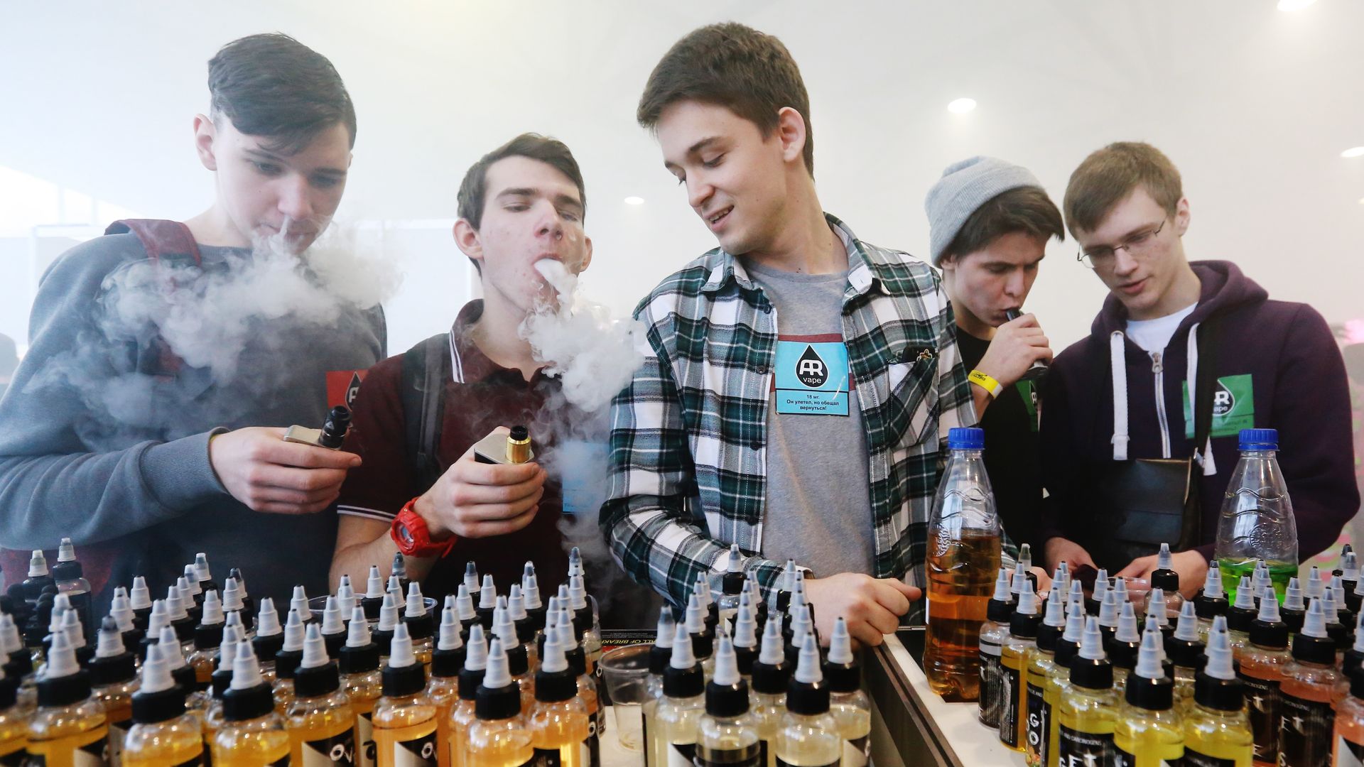 Teens at a Russian vaping expo looking at the goods and vaping