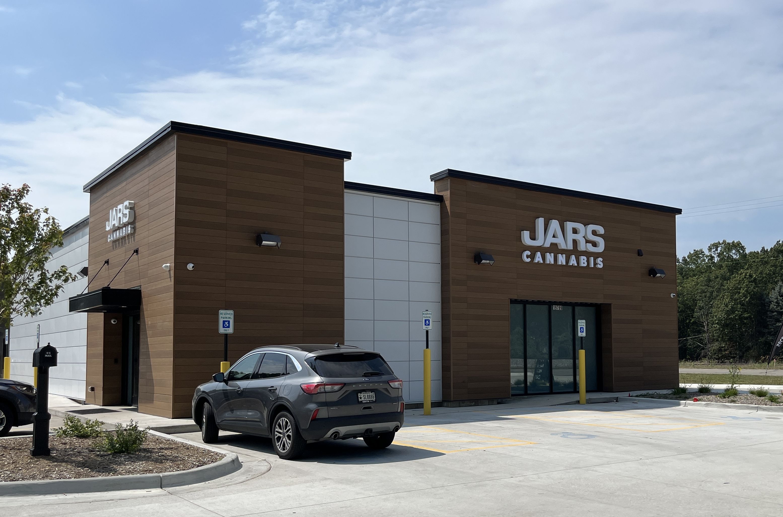 large cannabis store with a car in front 