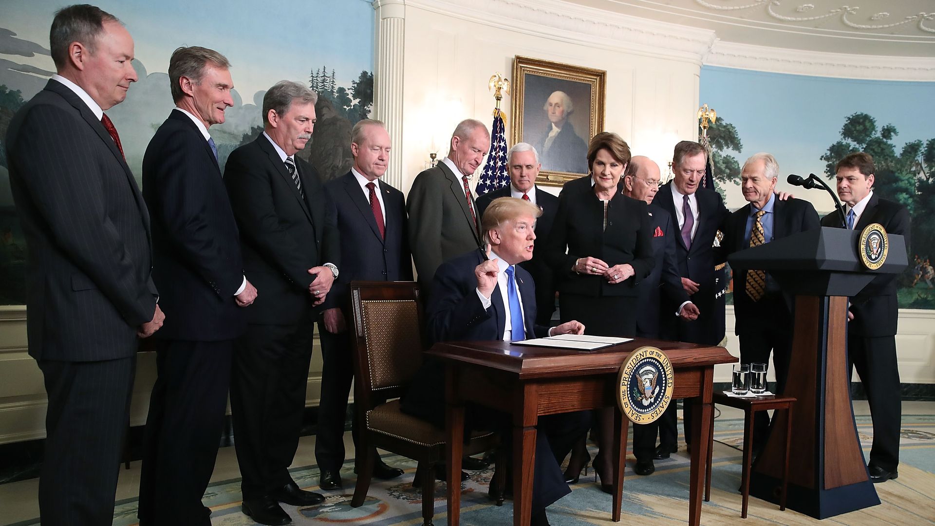 President Trump flanked by members of the business community as he signs a memorandum aimed at what he calls Chinese economic aggression in the Roosevelt Room at the White House on March 22, 2018.