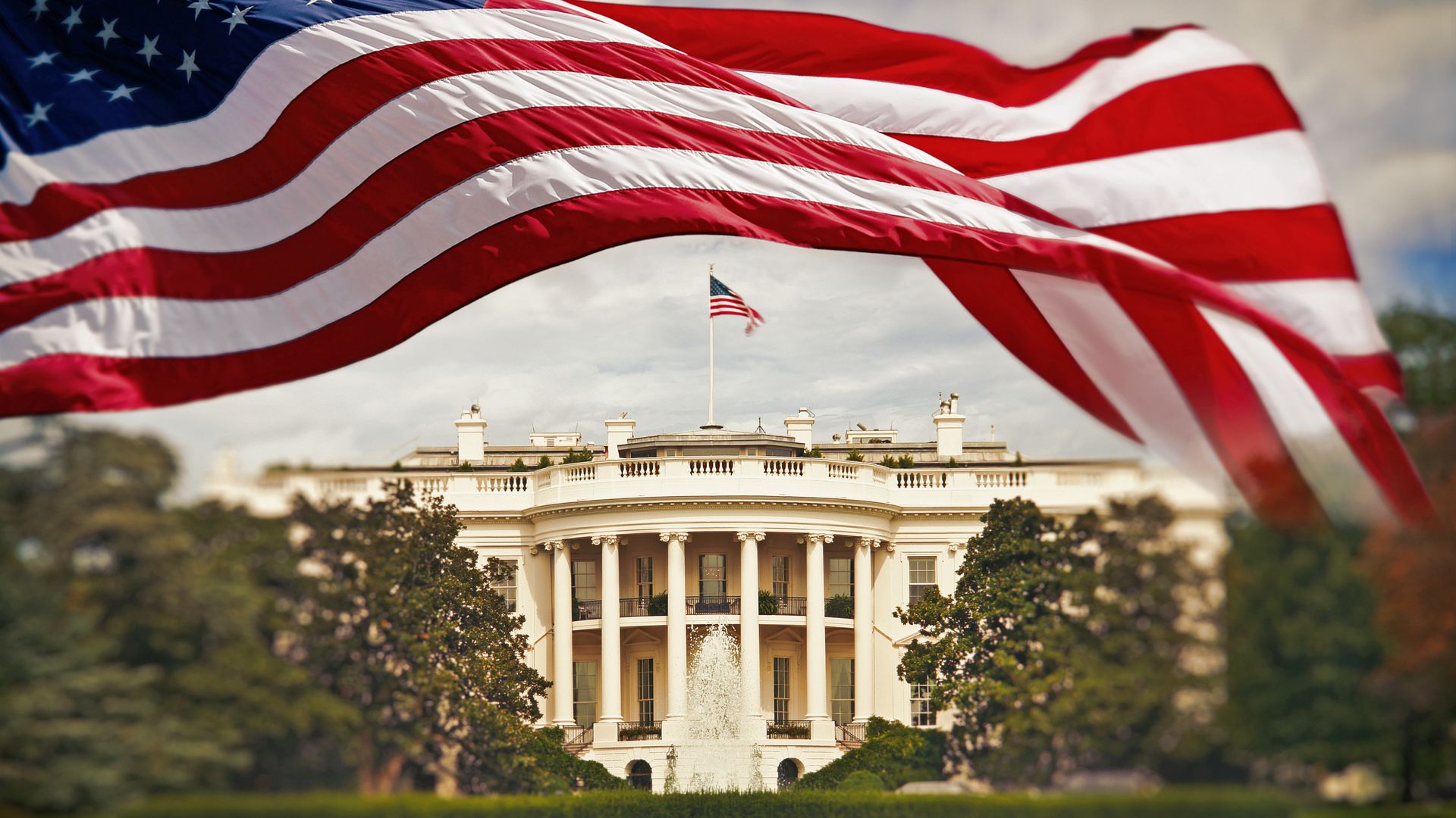 The White House in Washington DC with waving United States flag