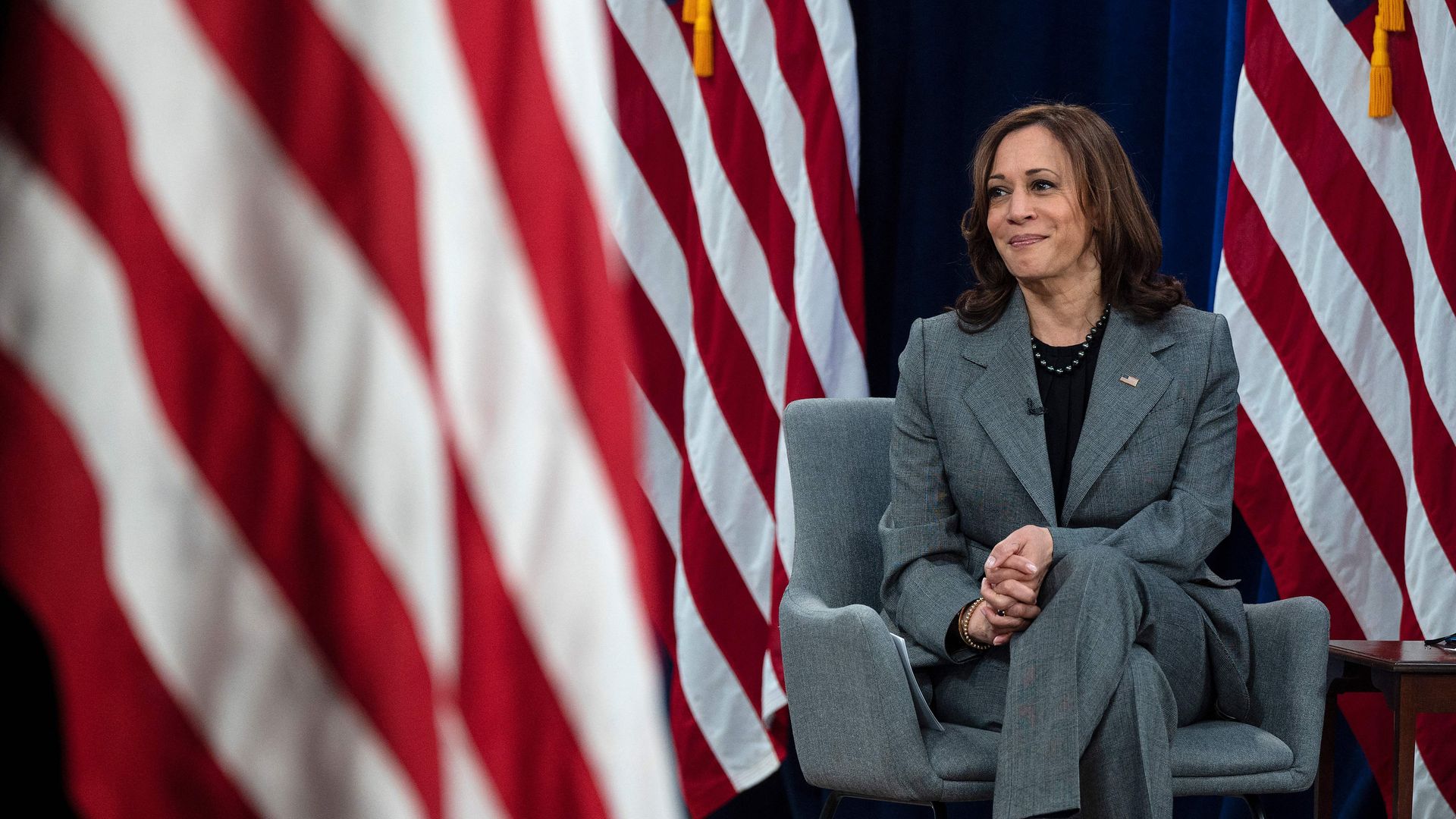 Vice President Kamala Harris is seen sitting among a spray of American flags.