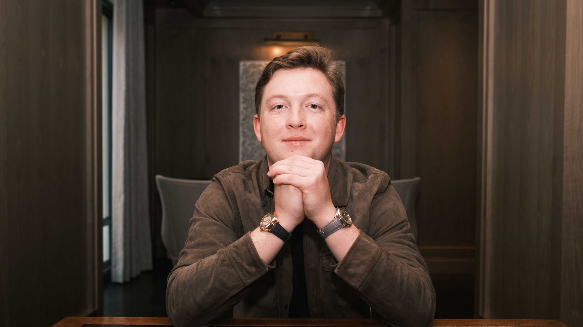 Thomas Fleming smiles with 2 watches and a jacket