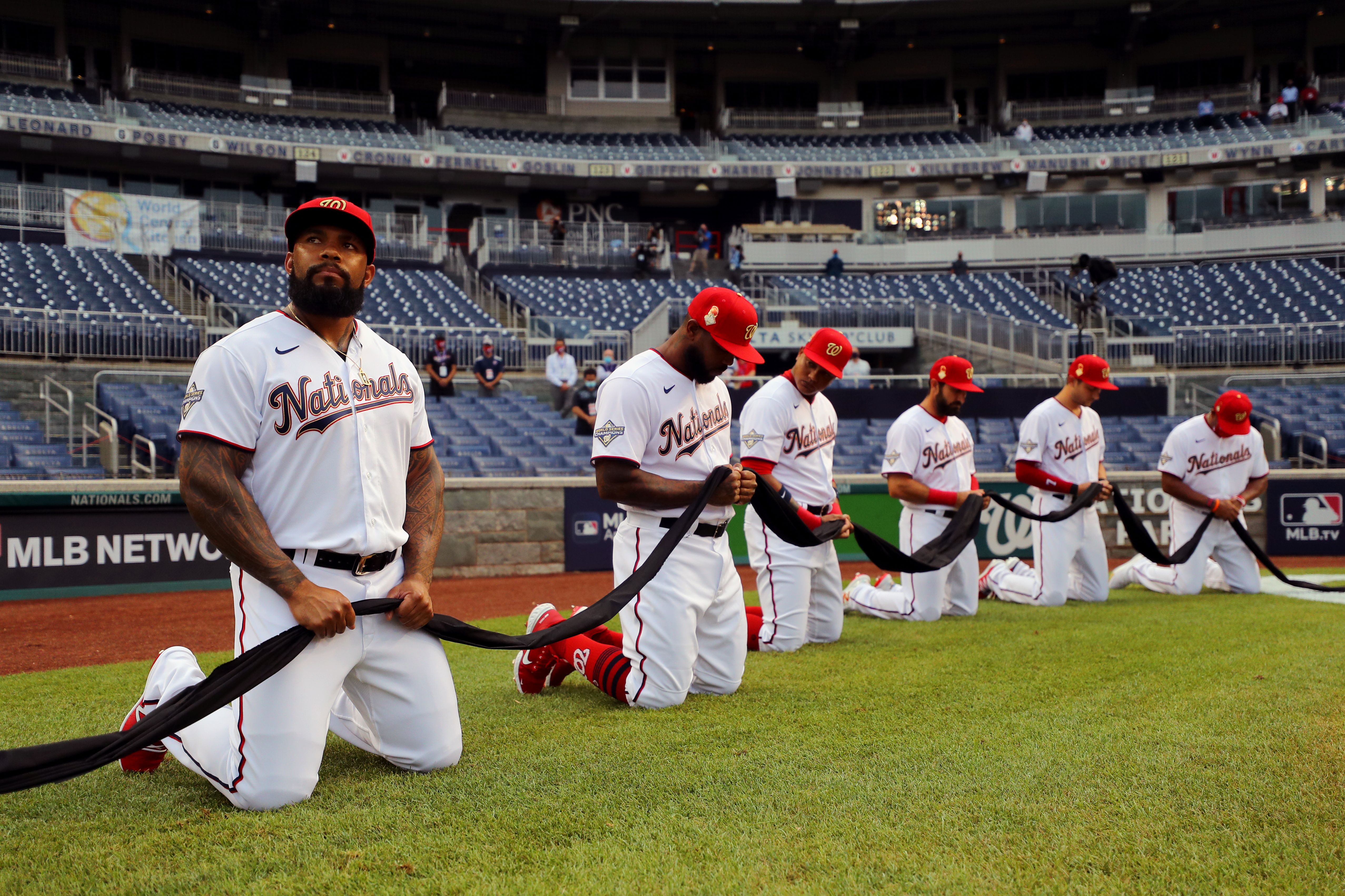 Nationals players kneeling and holding a black ribbon to show their support for the Black Lives Matter movement.