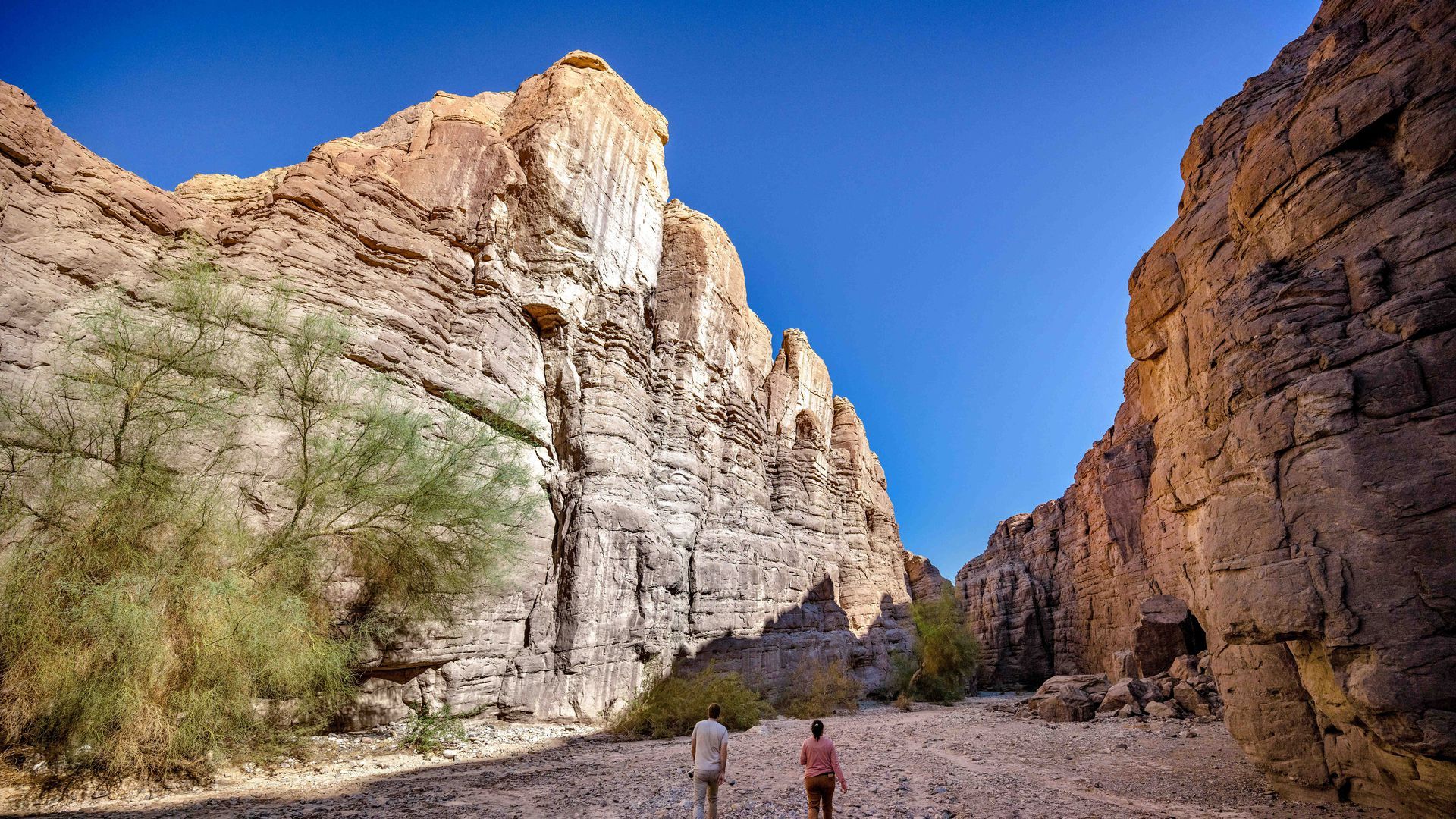 two people walk through a canyon in the wilderness in California