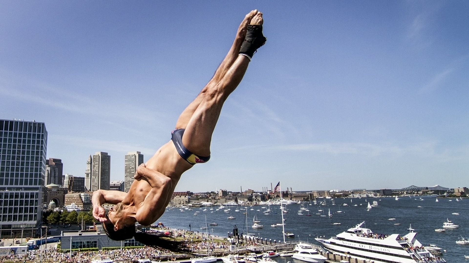 A man dives off 90 feet above the Boston Harbor.