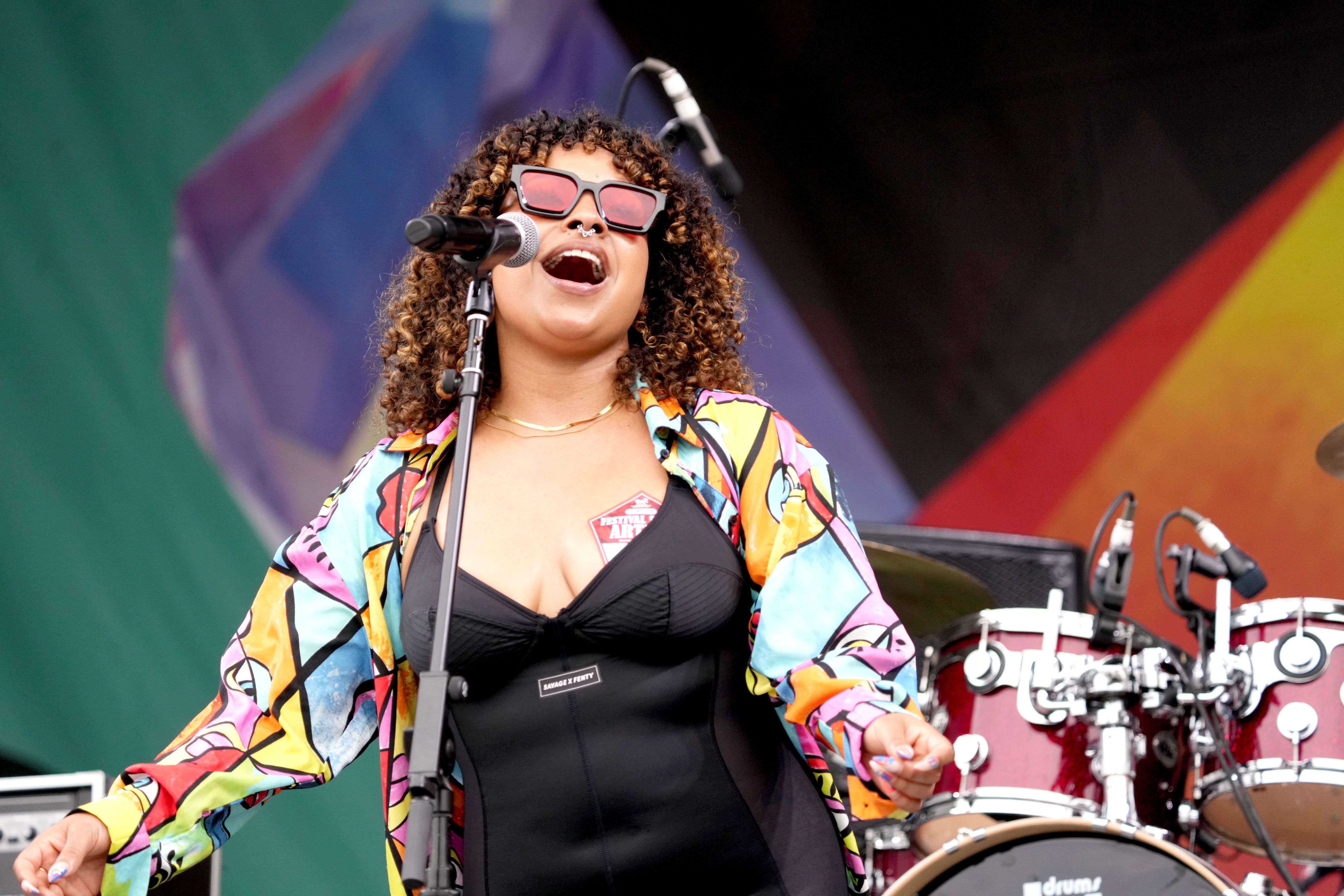 VIveca Hawkins sings into a microphone on the Jazz Fest stage.