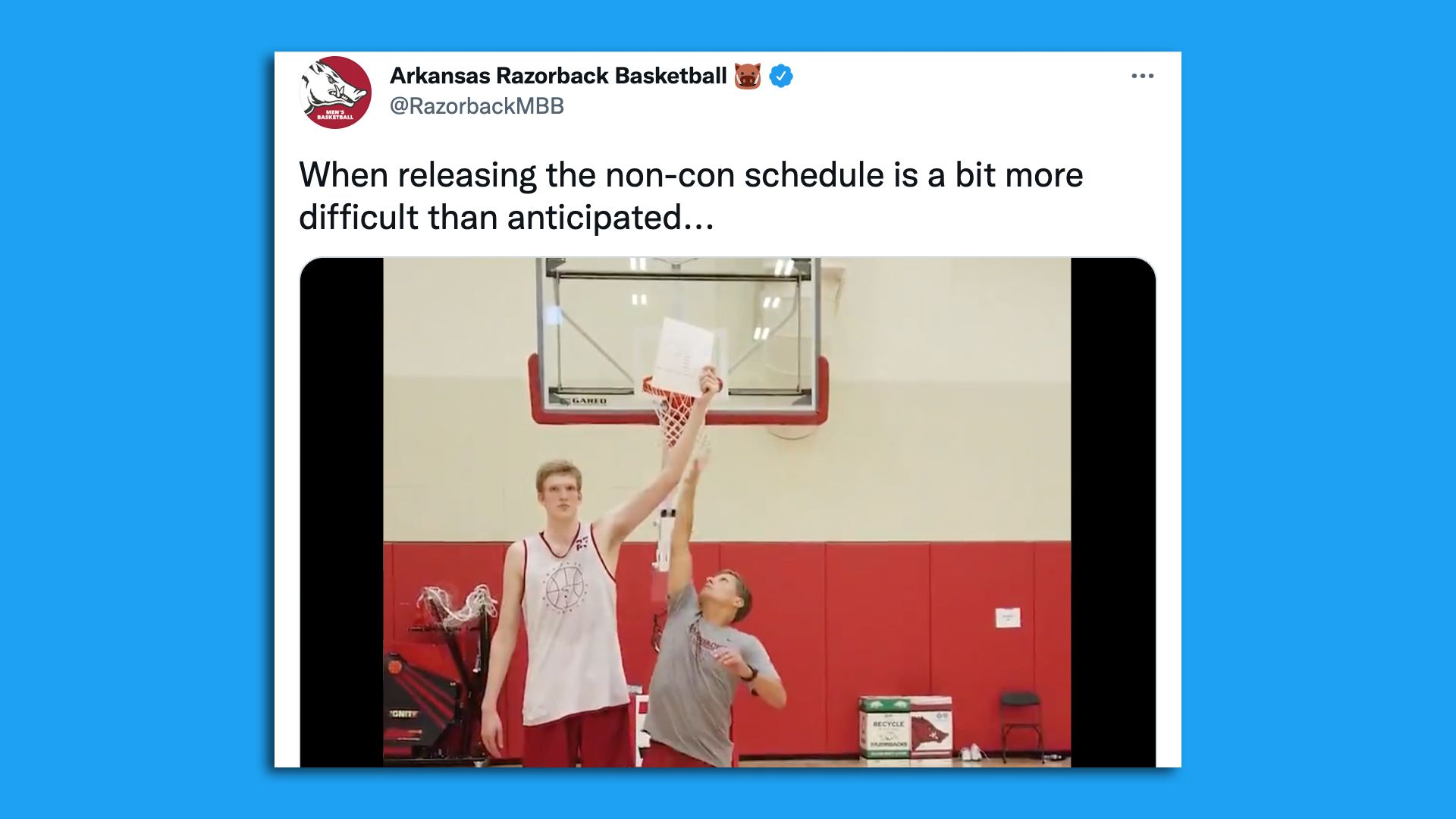 Screen shot of a tall basketball player holding a paper from his coach. 