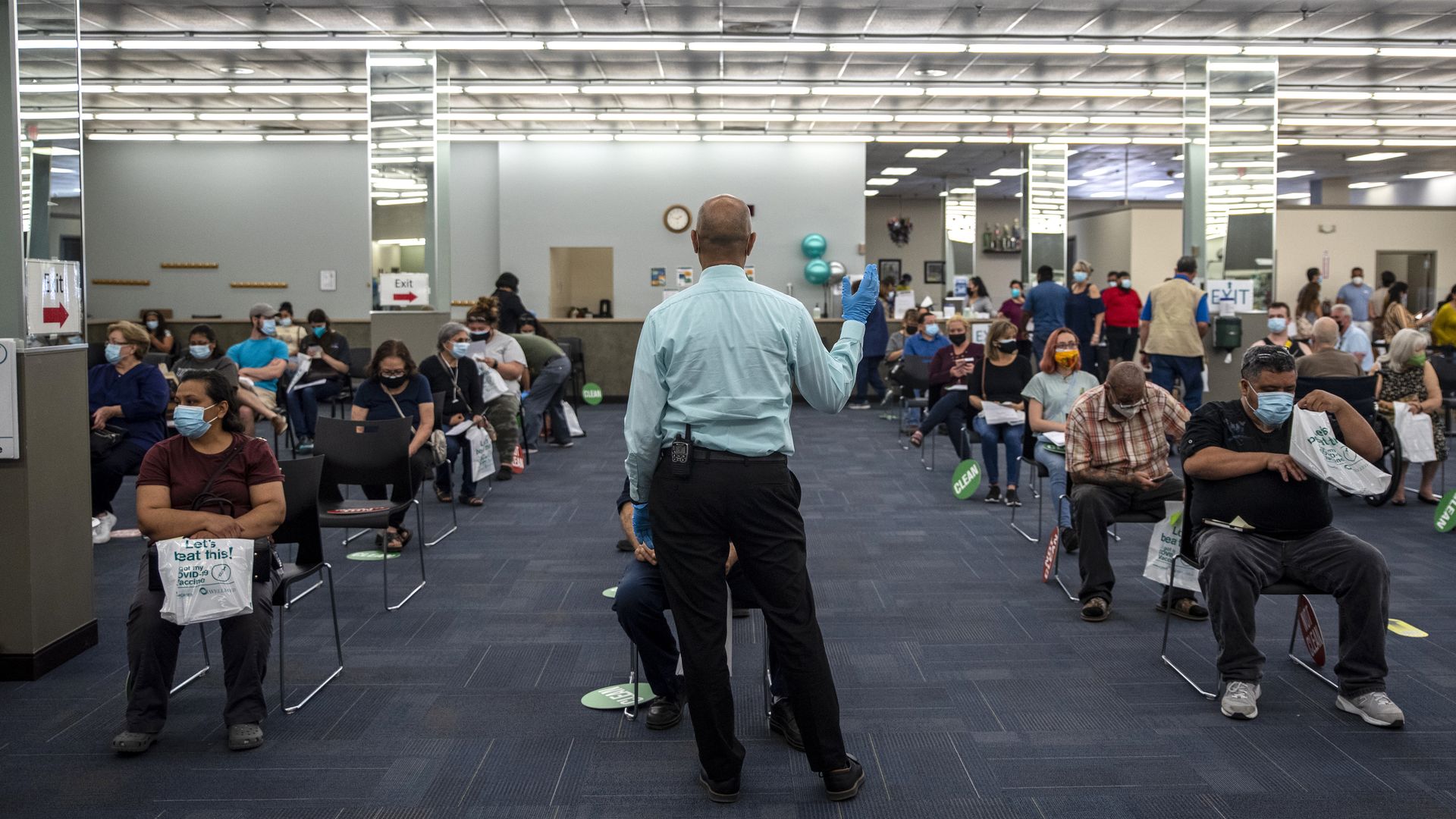 A worker calls out a time for some patients to be able to leave after being vaccinated at a vaccination site at a senior center on March 29, 2021 in San Antonio, Texas.