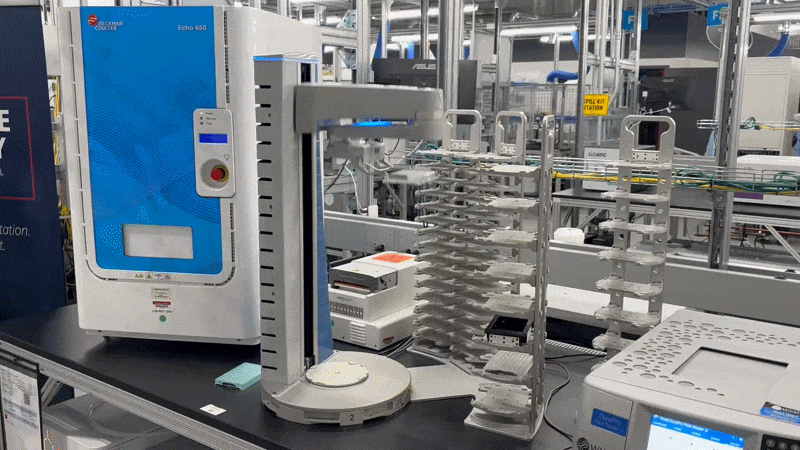 A robotic arm placing a plastic dish into place inside a lab