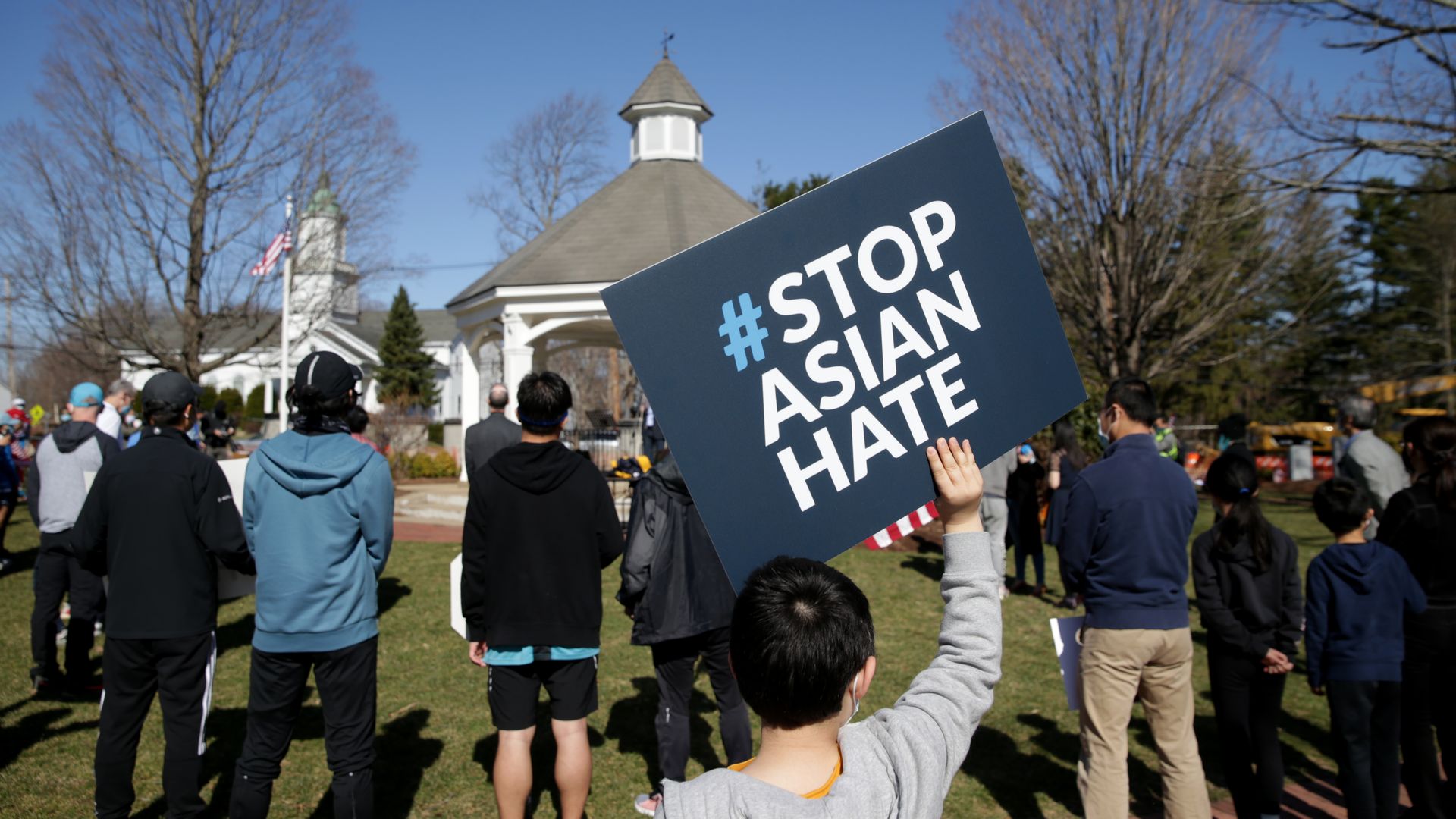 Photo of a person holding a #StopAsianHate sign at a rally
