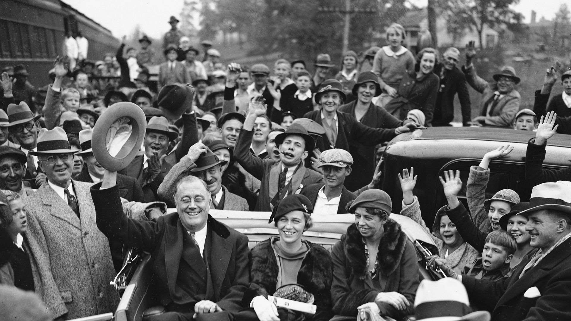 FDR waves to a crowd in a car
