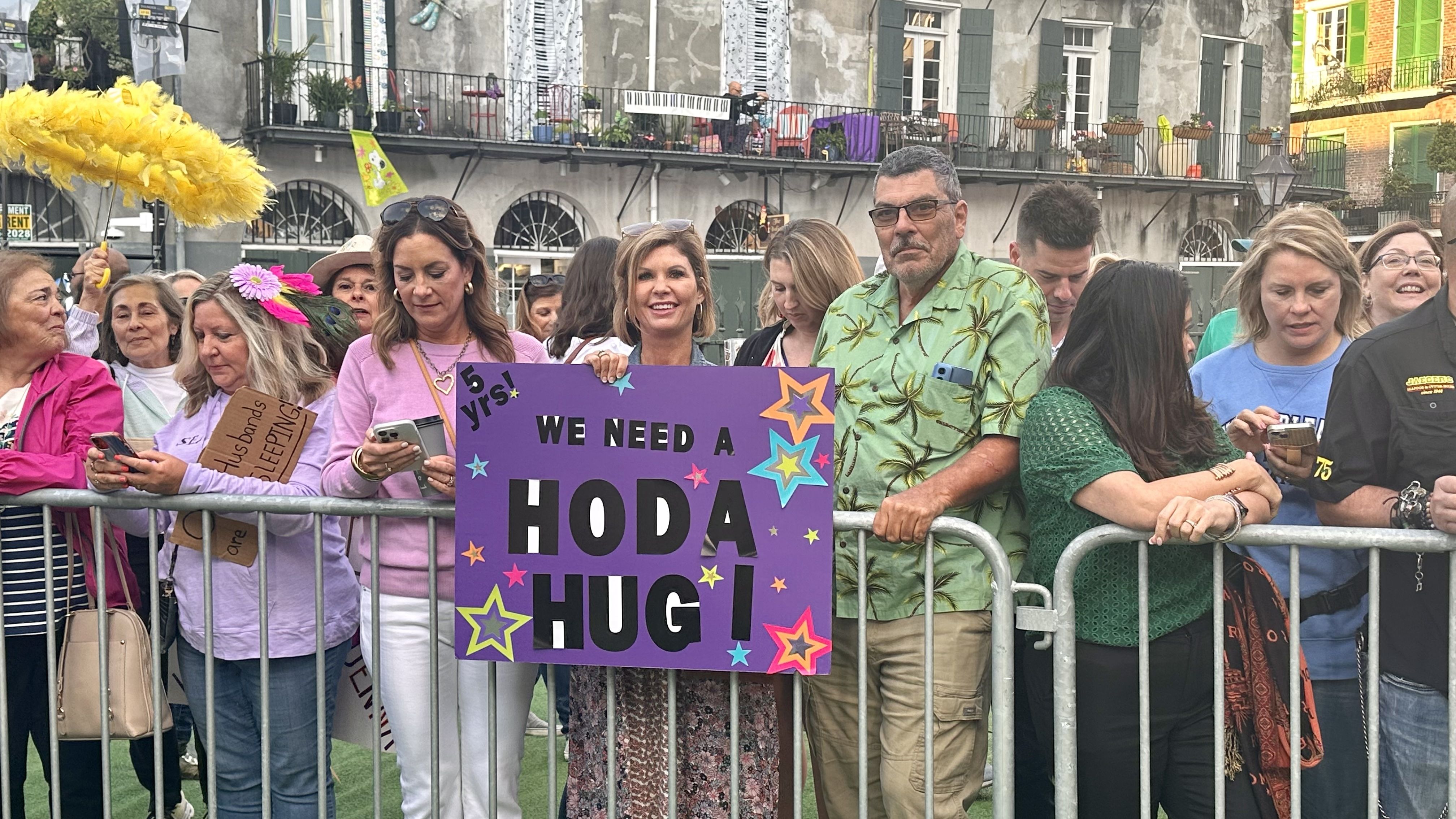 Photo shows a woman holding a sign that says "We need a Hoda hug"