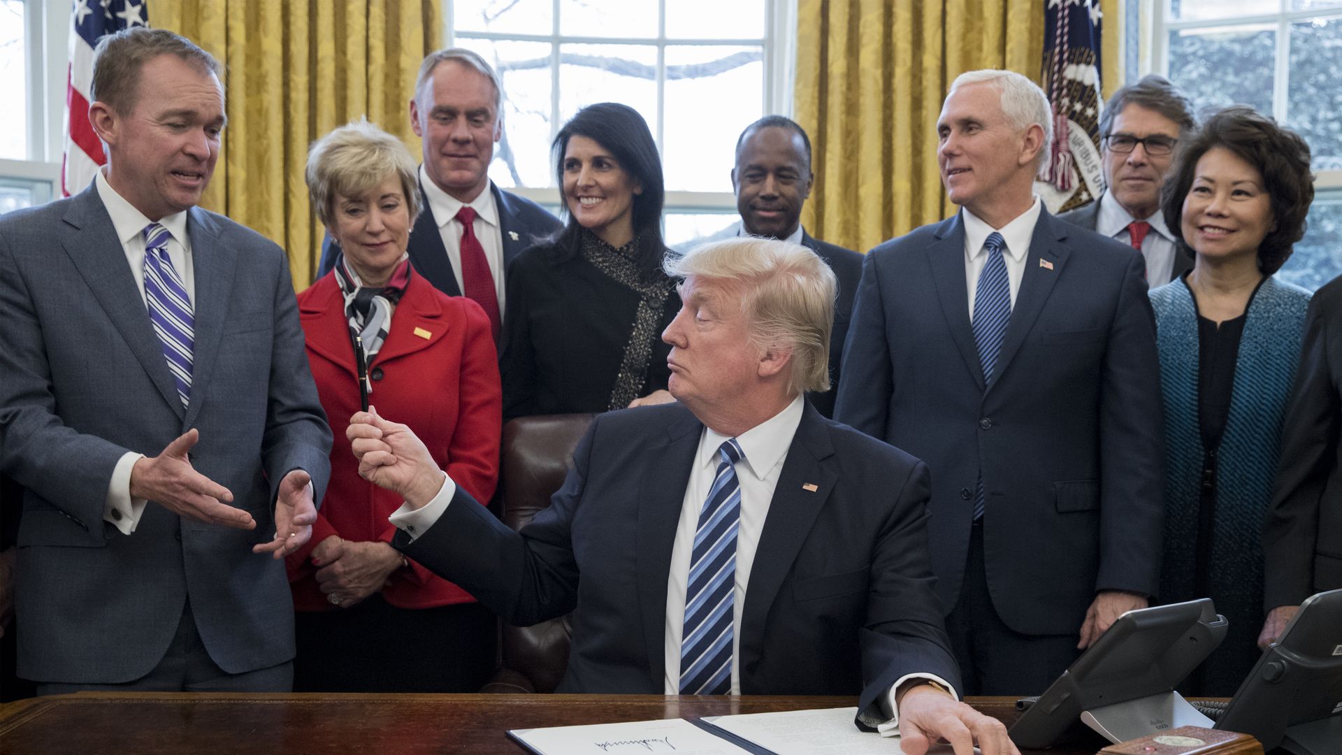 President Donald Trump hands his pen to Director of the Office of Management and Budget (OMB) Mick Mulvane