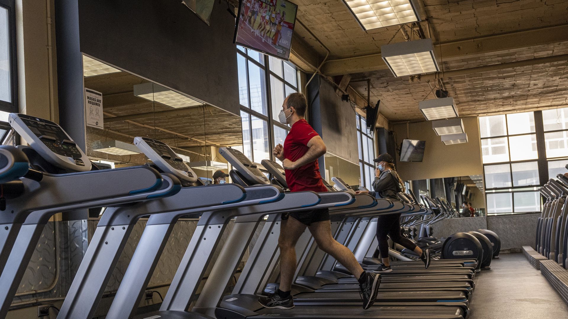 Picture of a row of treadmills, with only two being used
