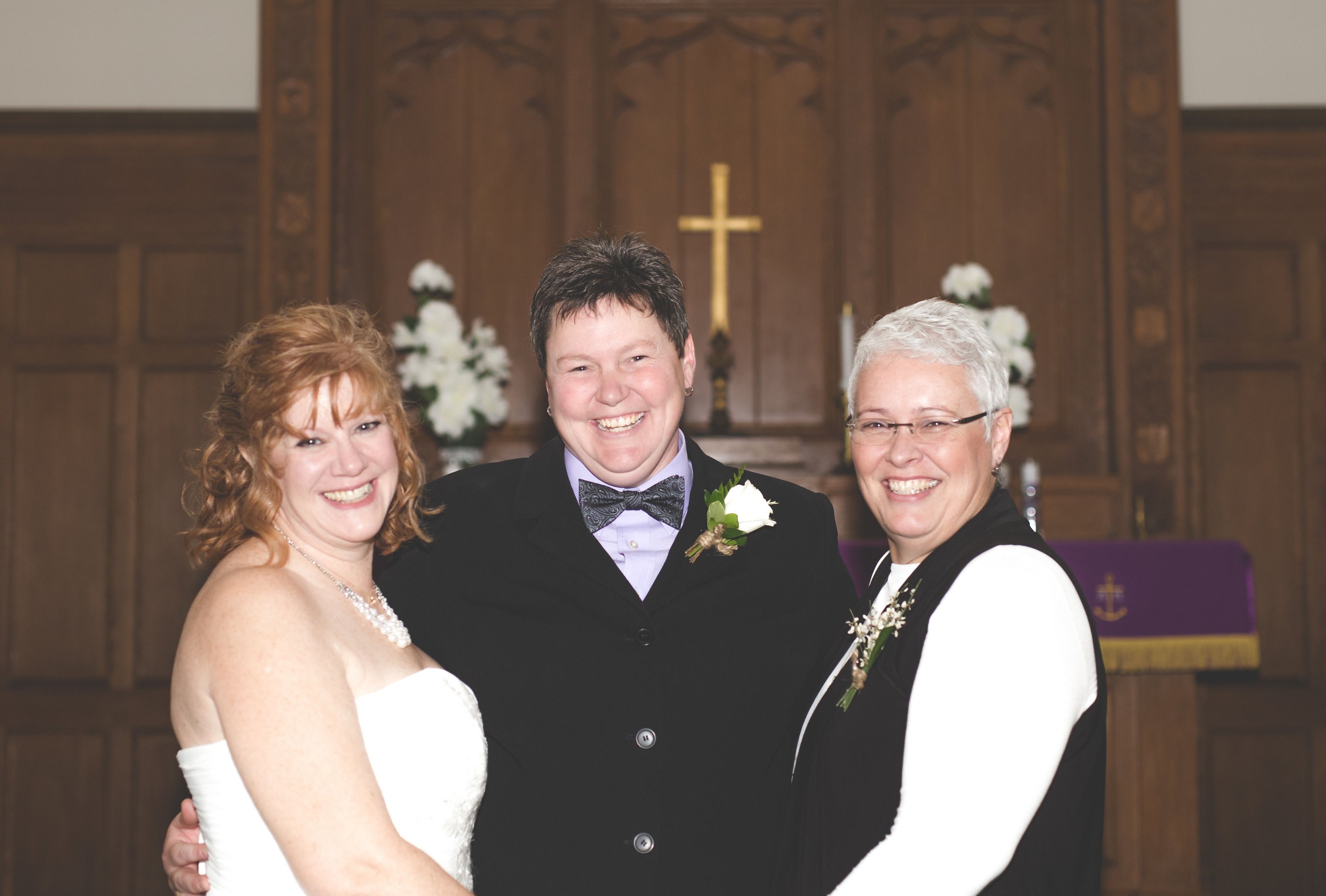 Jimmie, left, and Mindy, right, stand at the altar with their wedding officiant.