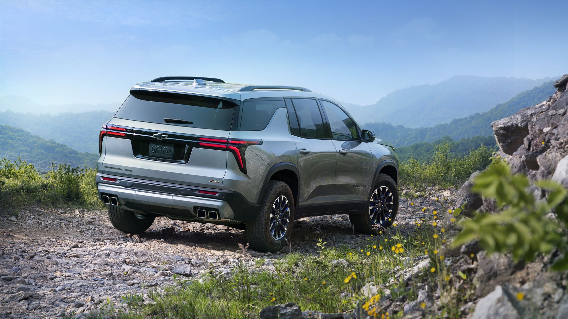 Passenger's side rear 3/4 view of 2024 Chevrolet Traverse Z71 in Sterling Gray Metallic parked on a gravel road.