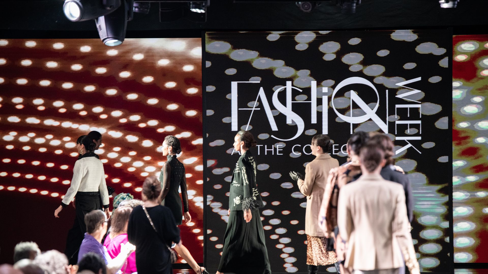 Models walk across a runway during a fashion show. 