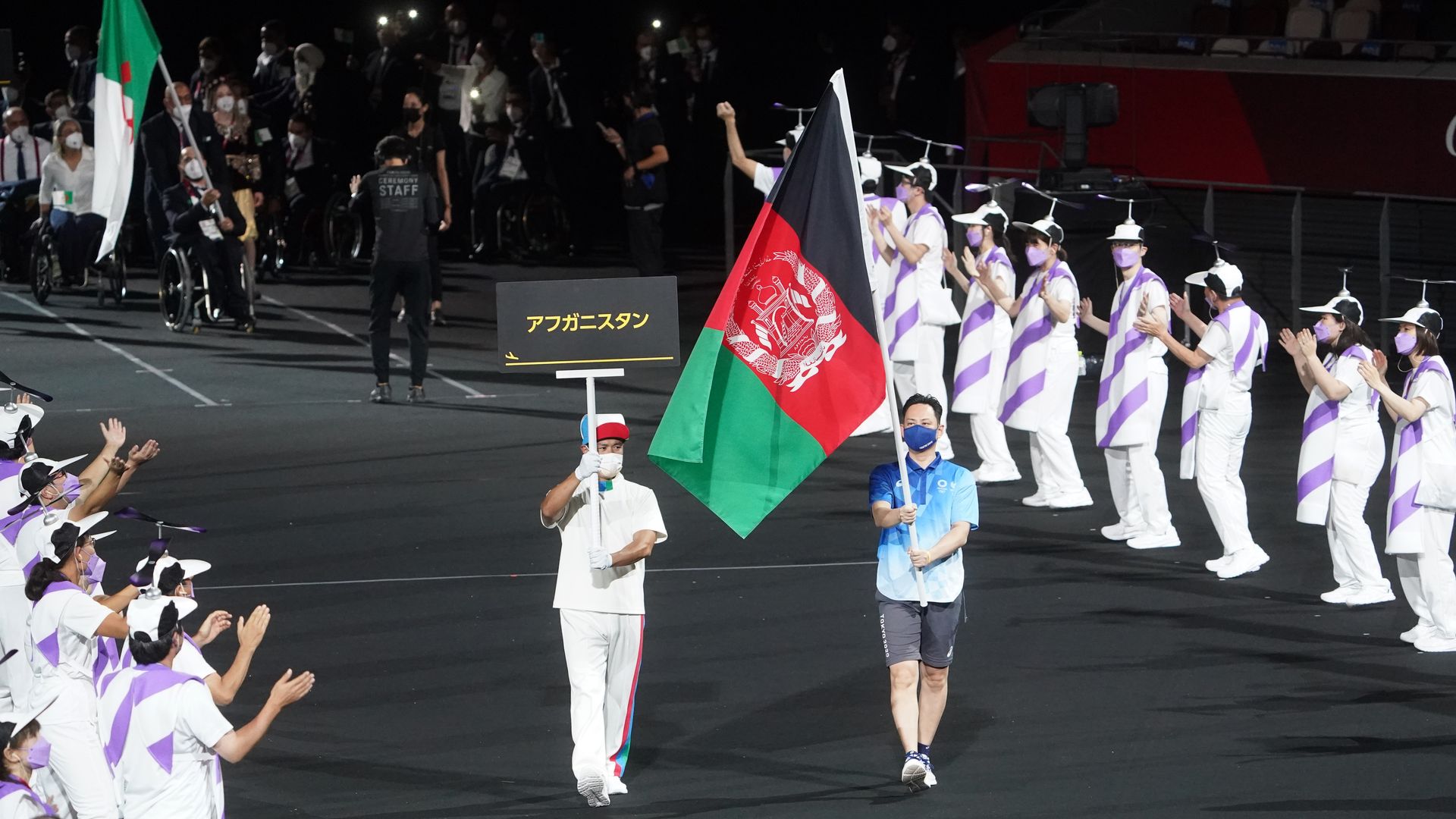 The flag of Afghanistan is presented by volunteers at the Paralympics
