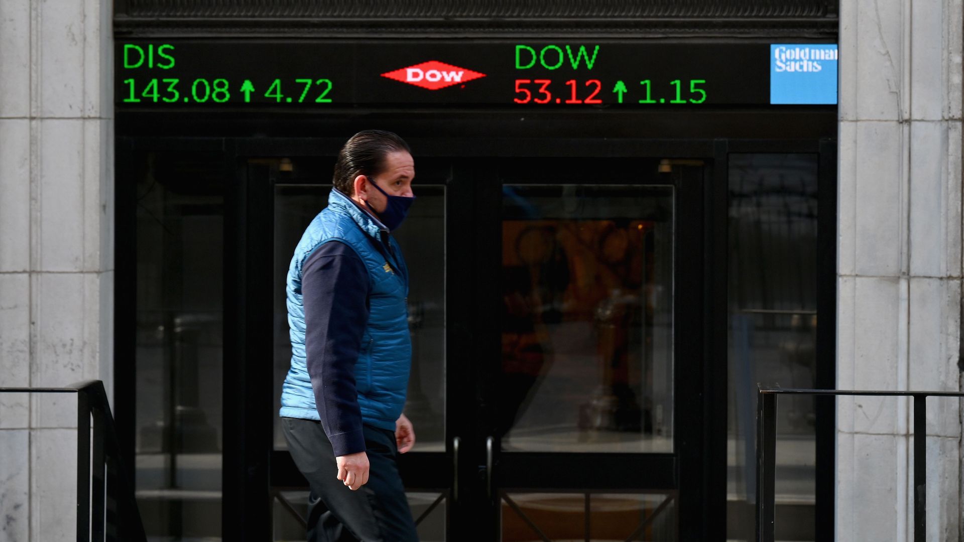 A masked trader walks outside the New York Stock Exchange in early November 