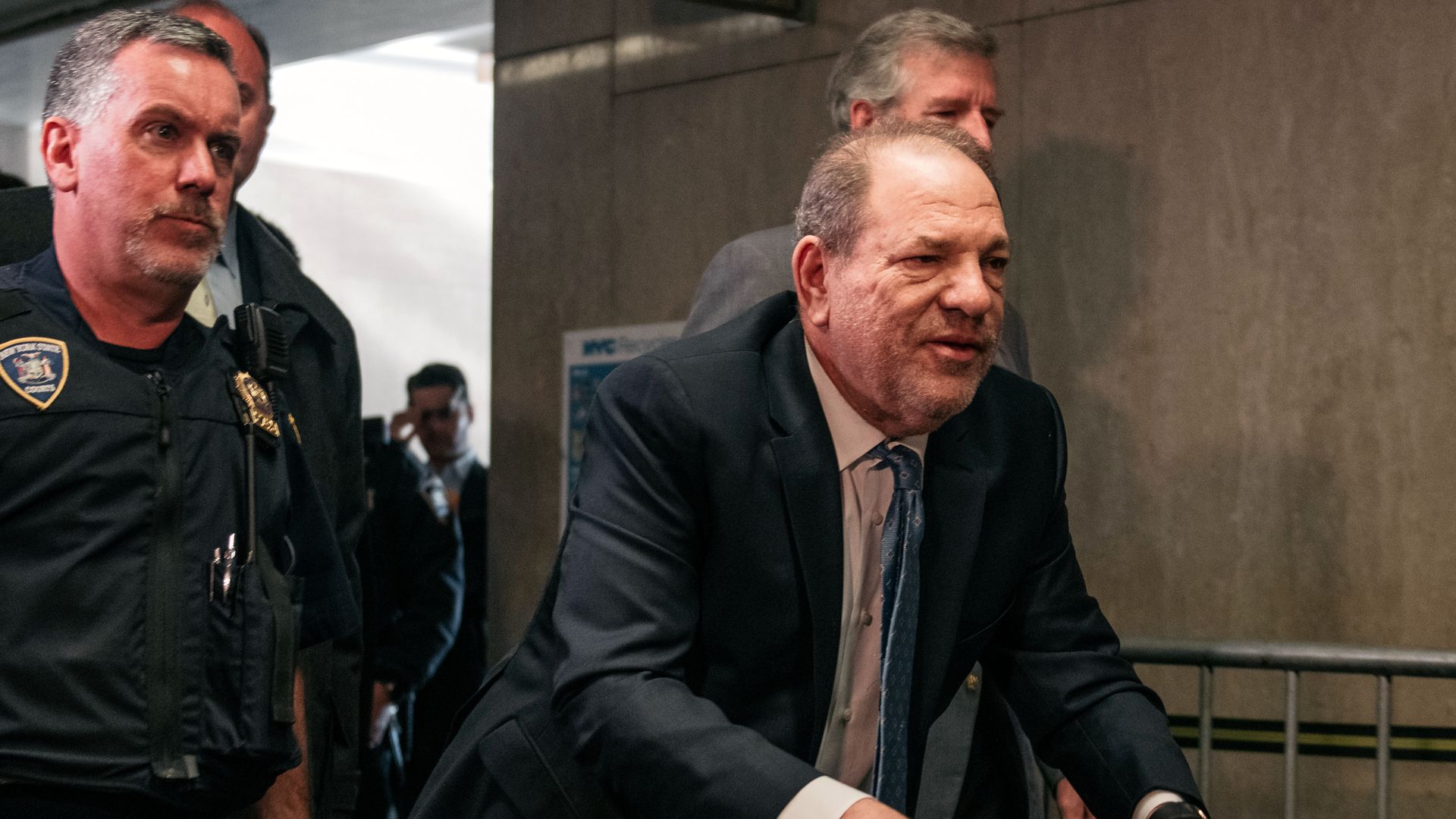 Picture of Harvey Weinstein with two police escorts