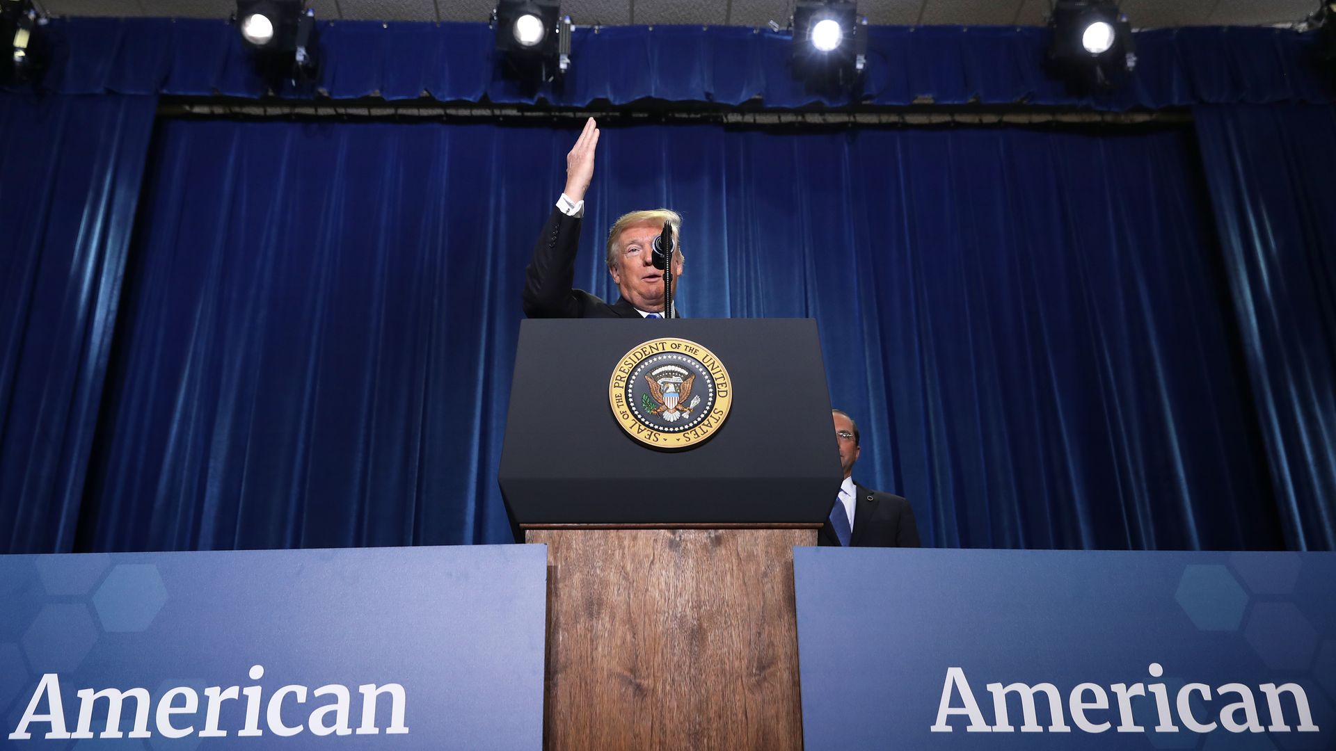 President Donald Trump on stage during a speech at the Department of Health and Human Services