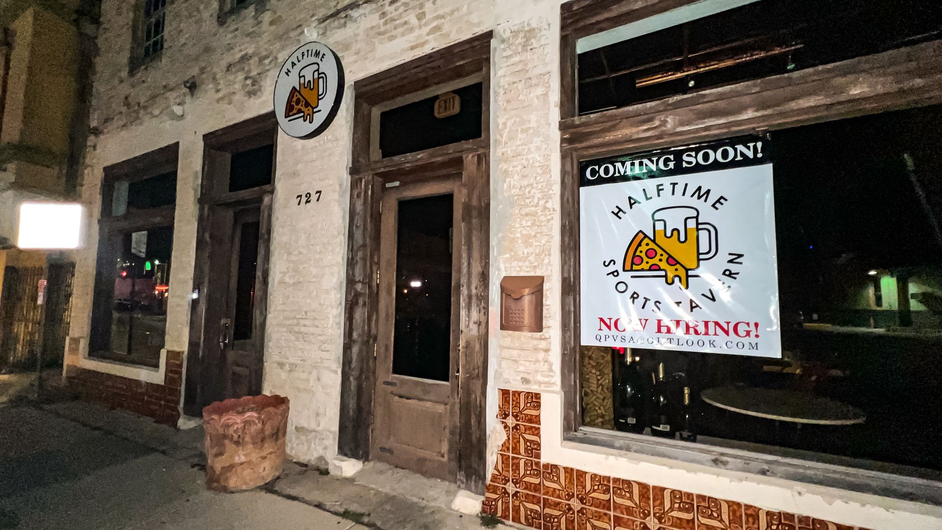 A brick building with a "coming soon" sign for Halftime Sports Tavern in the window.