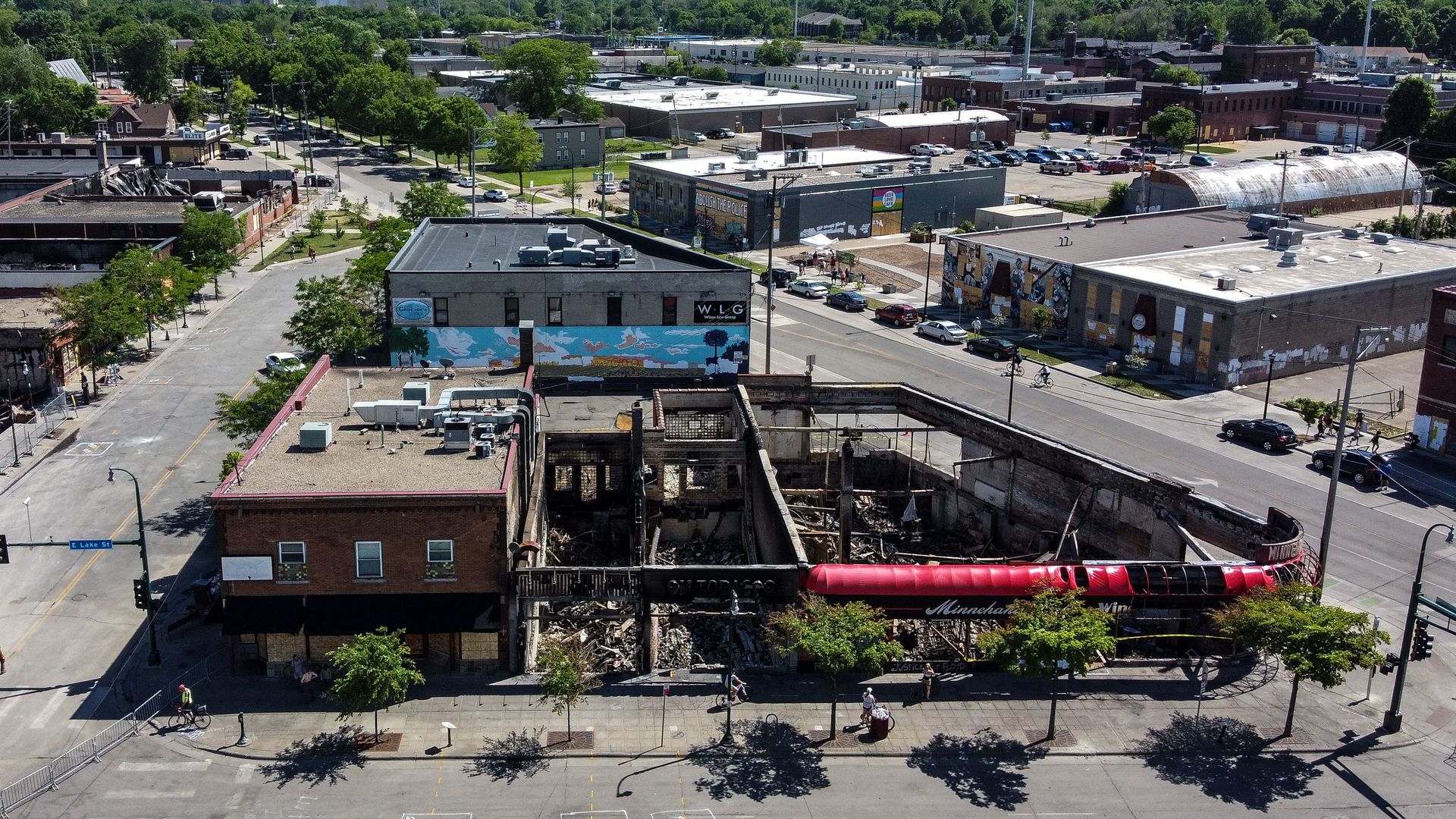 An aerial view of a burned out liquor store on a streetcorner on a sunny day