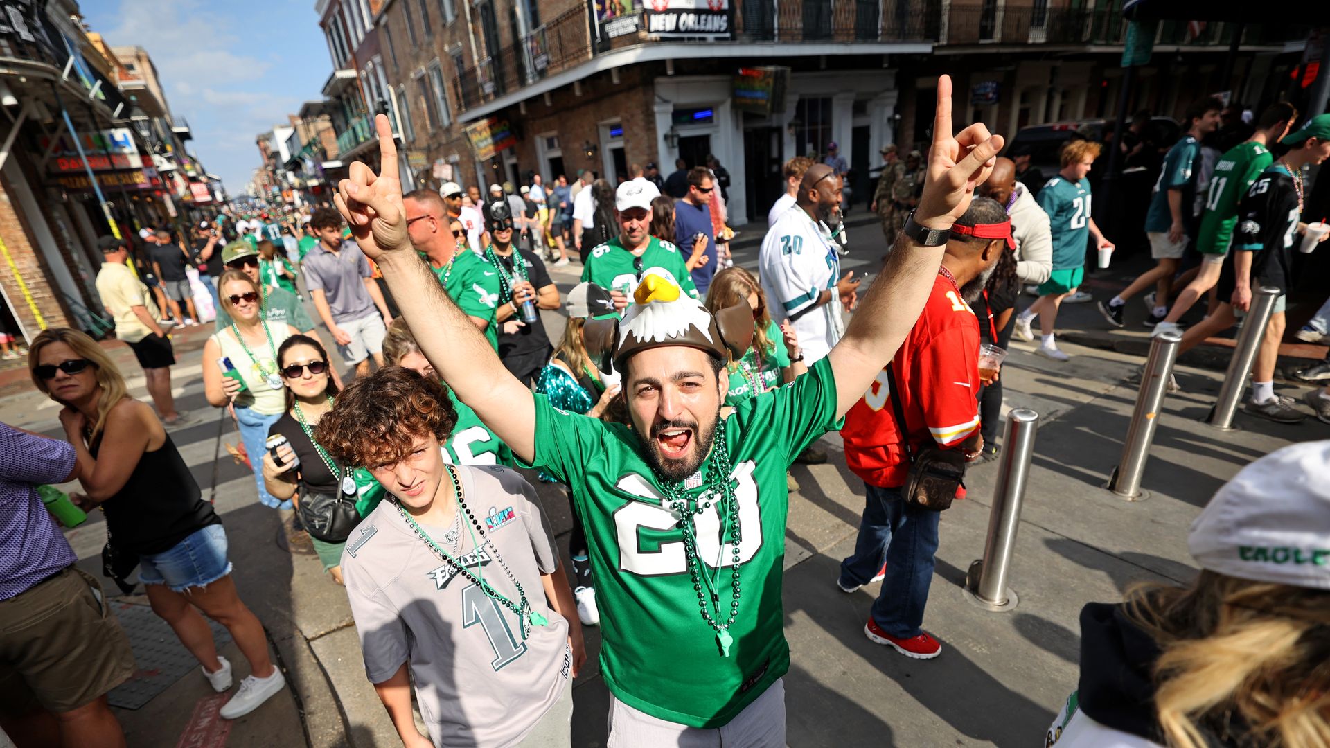 A fan in a Philadelphia Eagles jersey and hat makes a No. 1 sign on Bourbon Street.