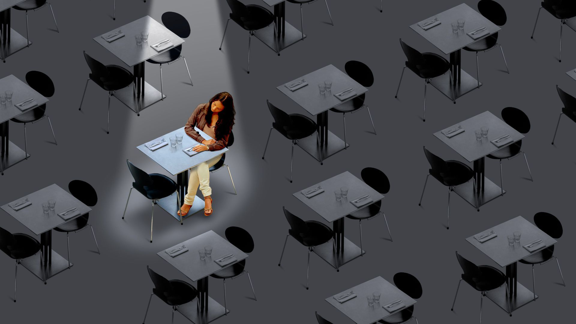 A woman is seated alone in a restaurant, with a spotlight on her table. 