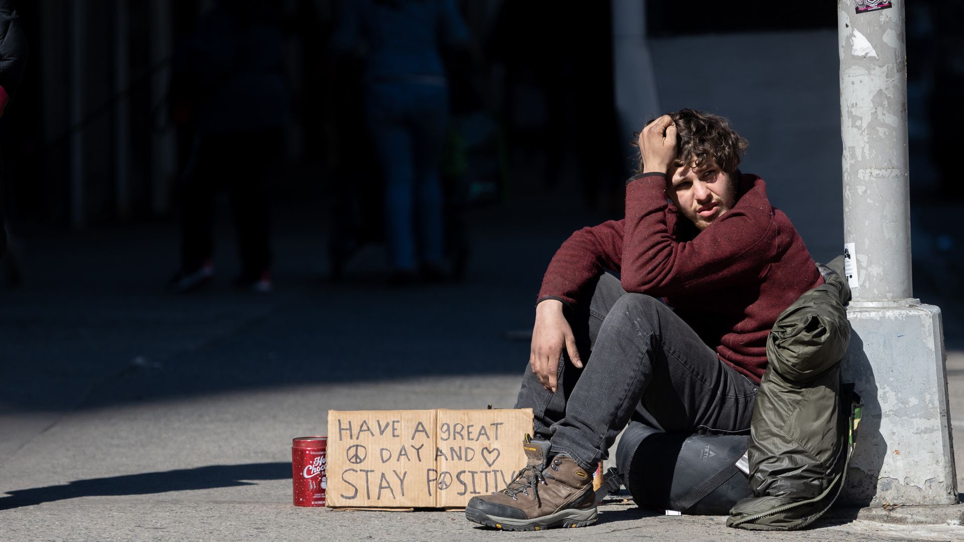 A person sitting on a sidewalk on March 13 in New York City.