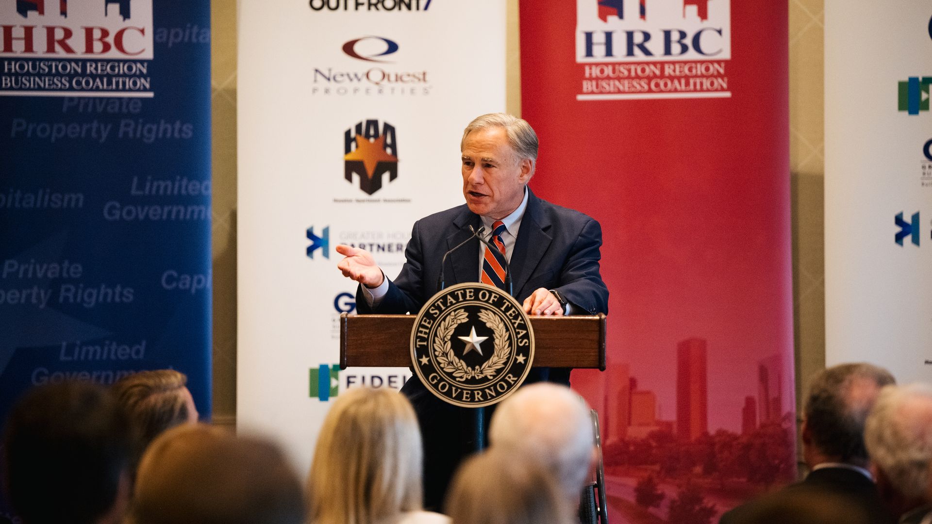 Photo of Greg Abbott speaking from a podium to a crowd of people