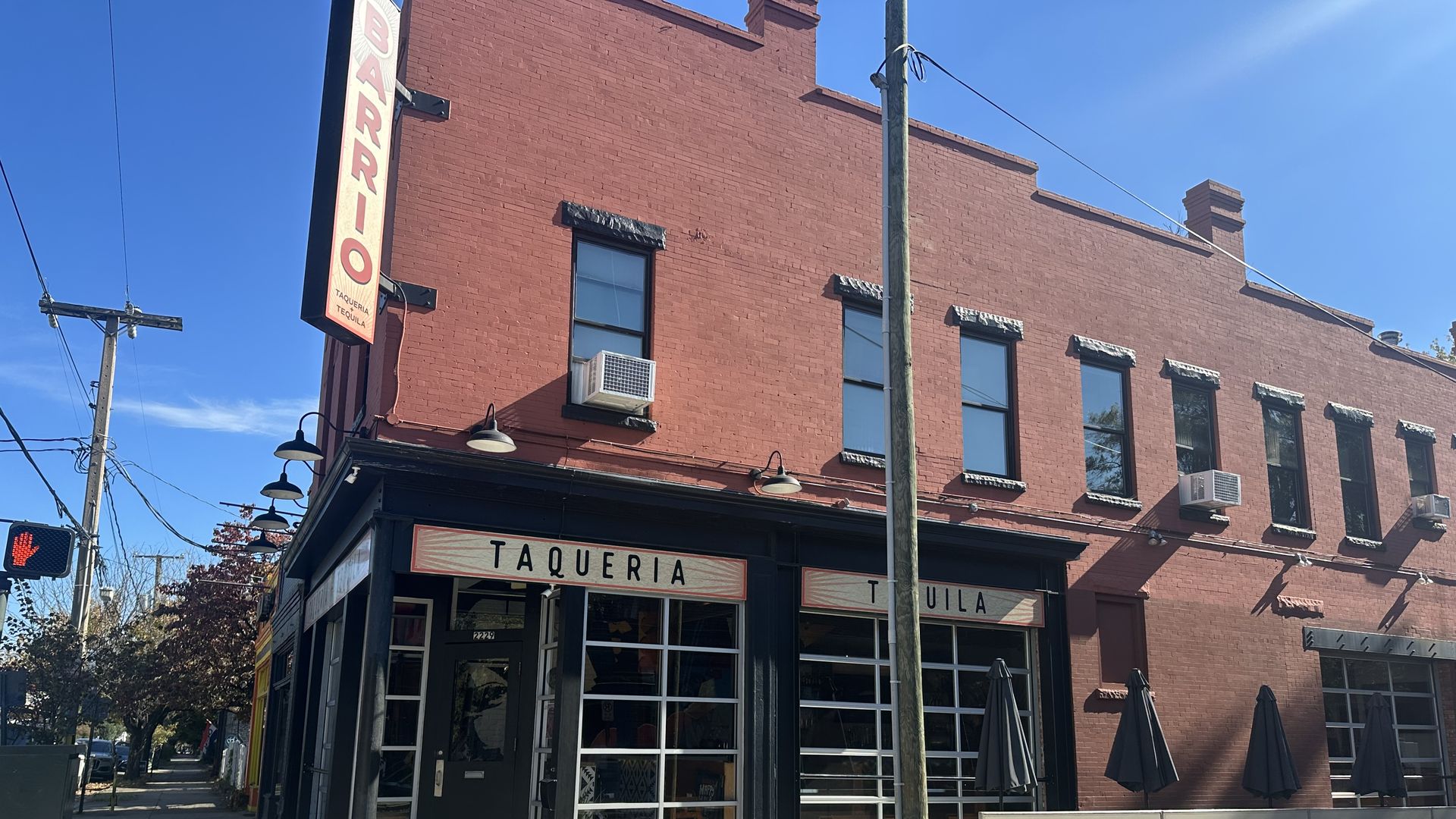 The outside of a corner, 2-story restaurant with the name Barrio on the side.