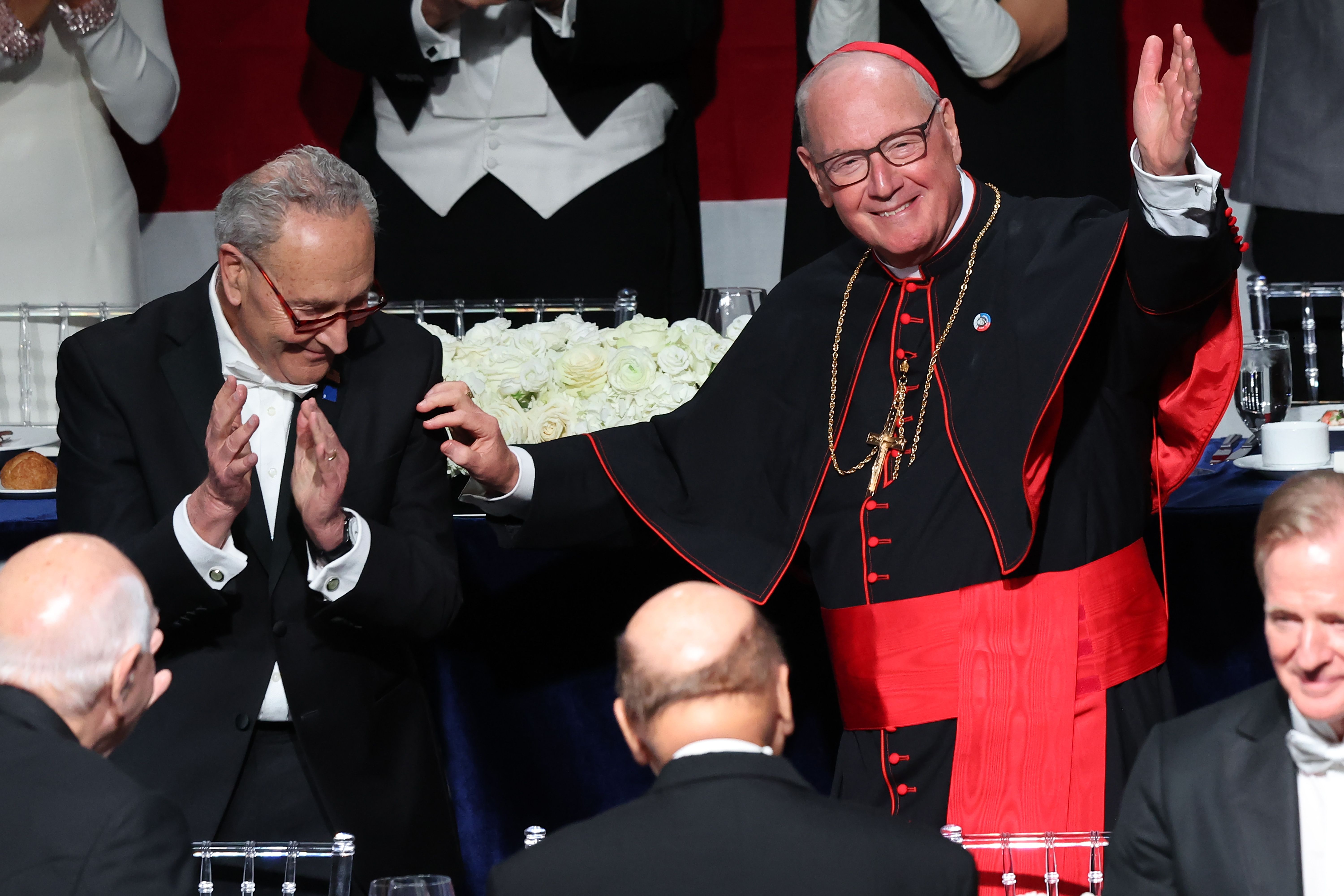 U.S. Senate Majority Leader Chuck Schumer (D-NY) claps as Cardinal Timothy Dolan arrives at the annual Alfred E. Smith Foundation Dinner at the New York Hilton Midtown on October 17, 2024 in New York City. 