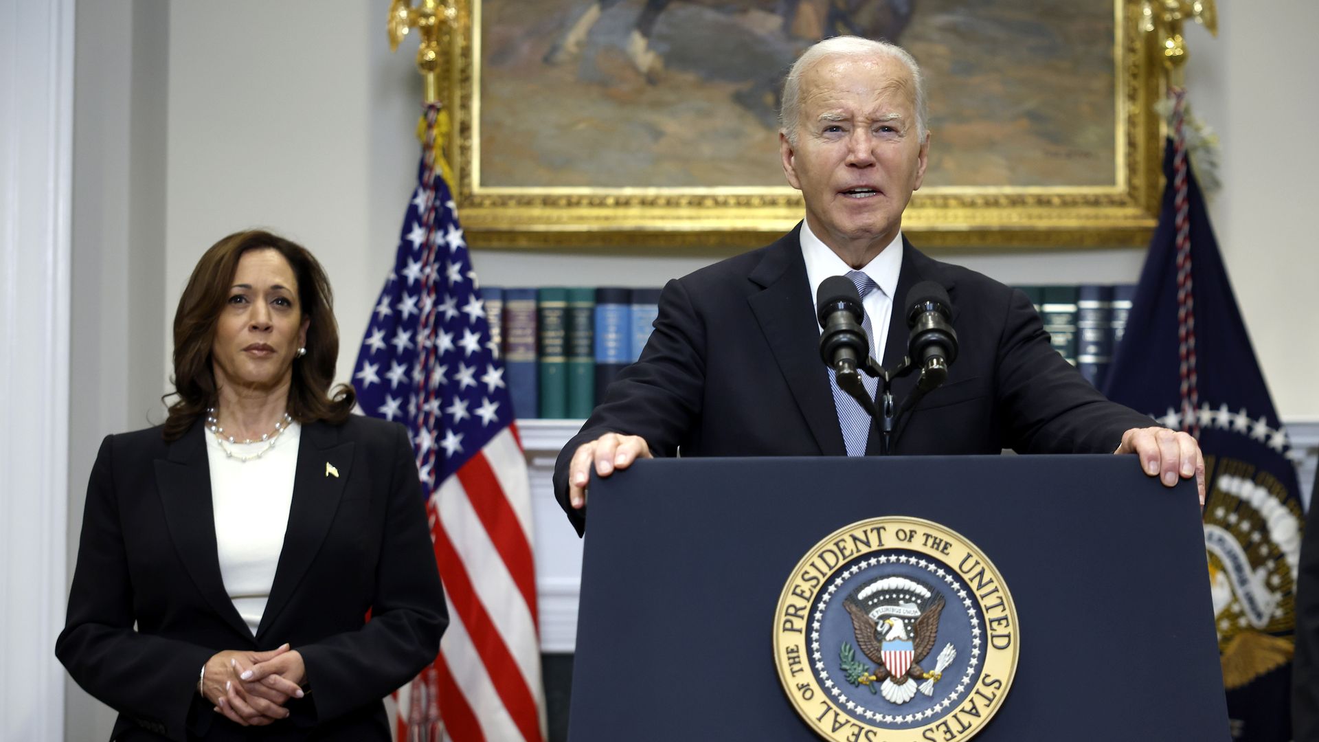 President Biden speaks while Vice President Kamala Harris watches on.