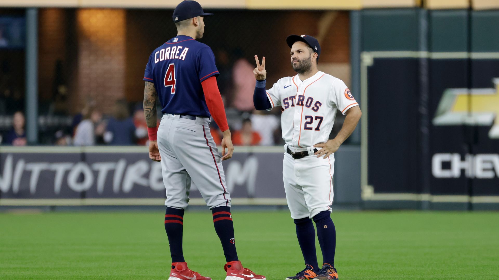Carlos Correa and Jose Altuve speak on the field during a game 