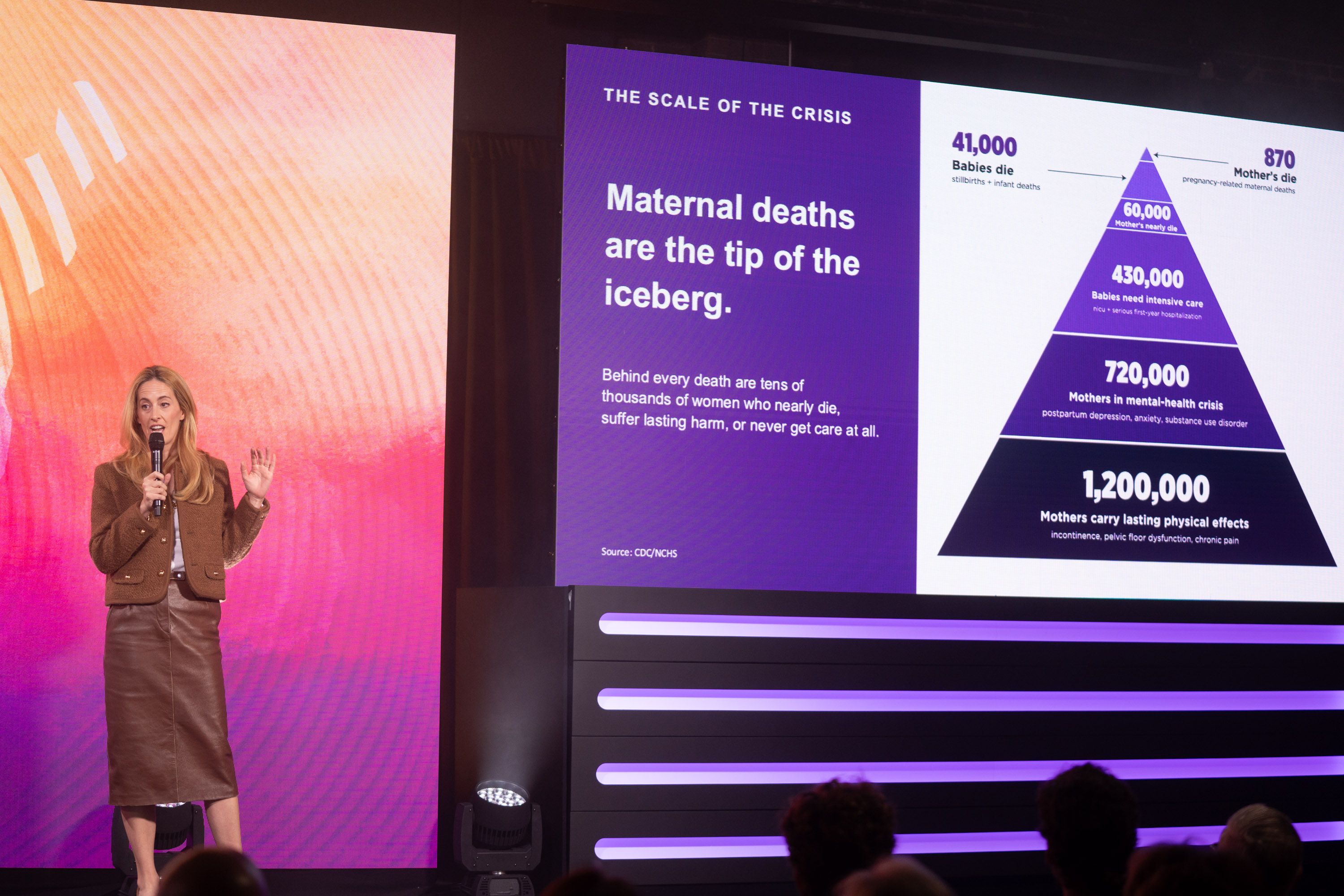Olivia Walton onstage with graphic about maternal health crisis