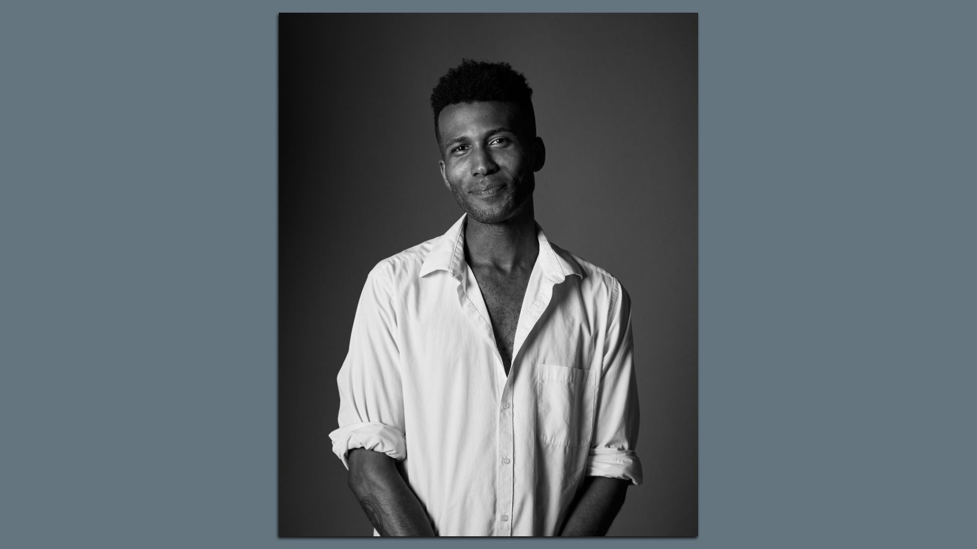 Black-and-white portrait of Robertson, wearing a white button-down shirt, against a gray studio backdrop.