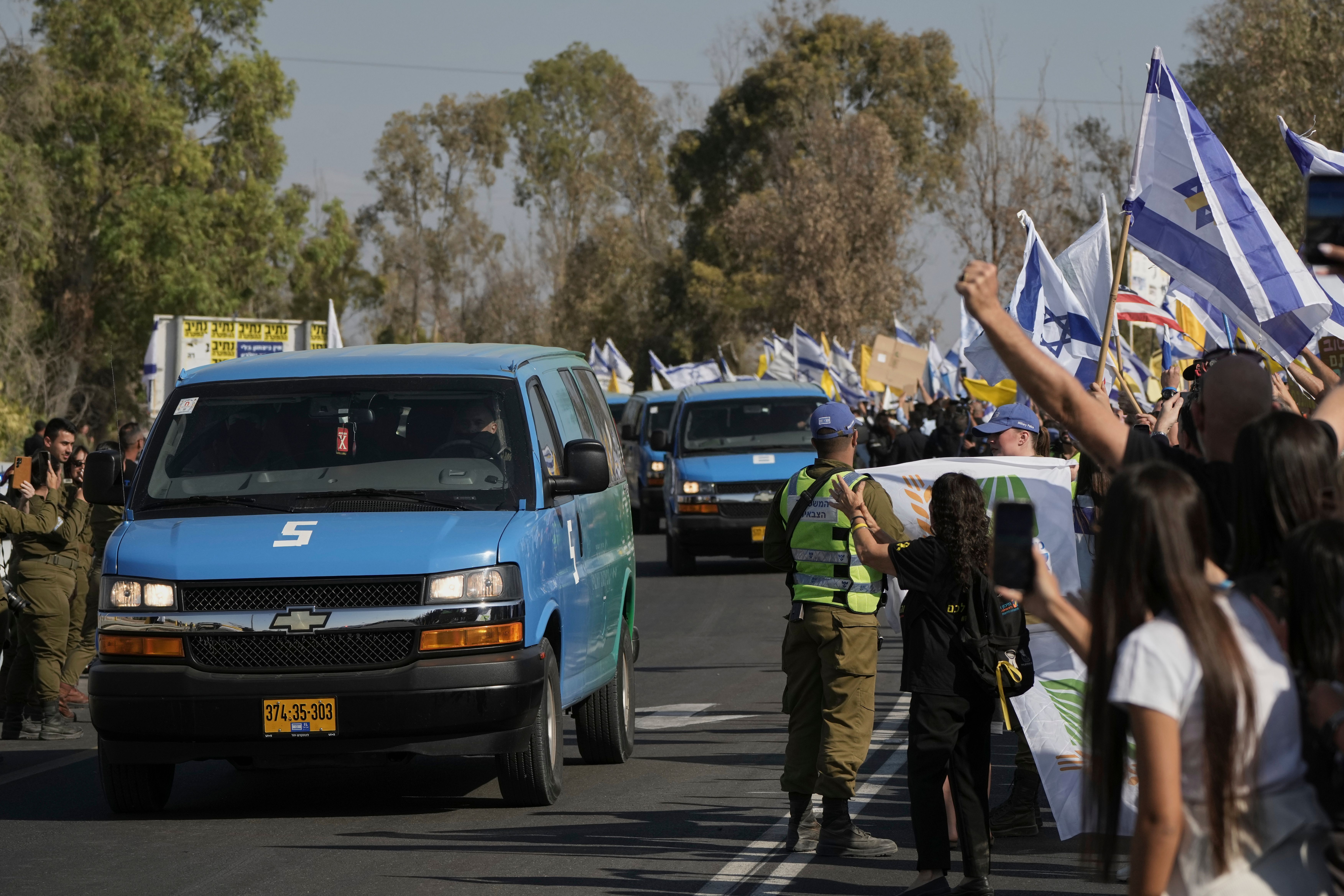People react as a convoy carrying the hostages released from the Gaza Strip arrives at a military base near Reim, southern Israel, on Monday, Oct. 13, 2025. (AP Photo/Leo Correa)