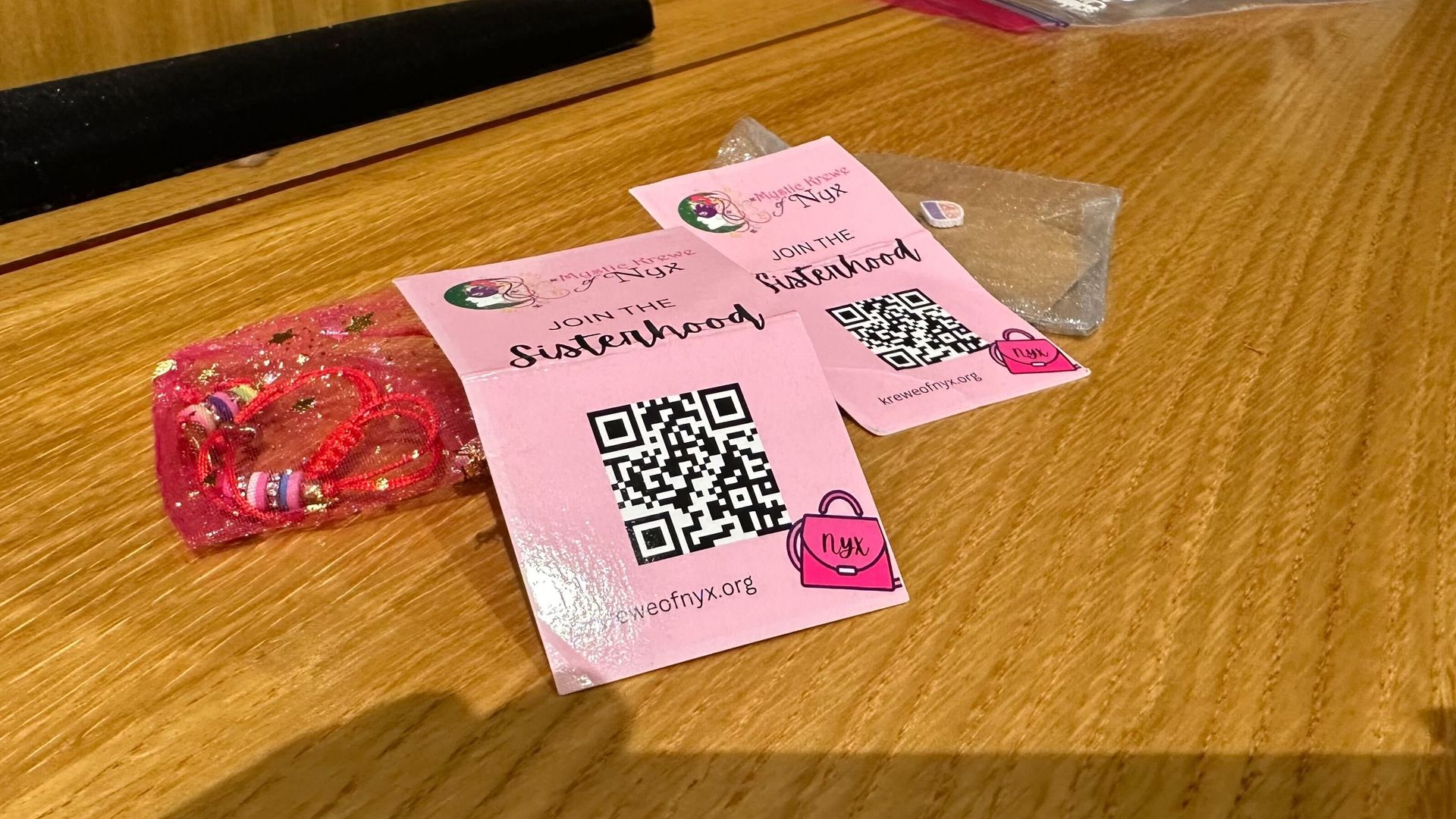 Mardi Gras throws from the Krewe of Nyx showing a QR code for membership card.