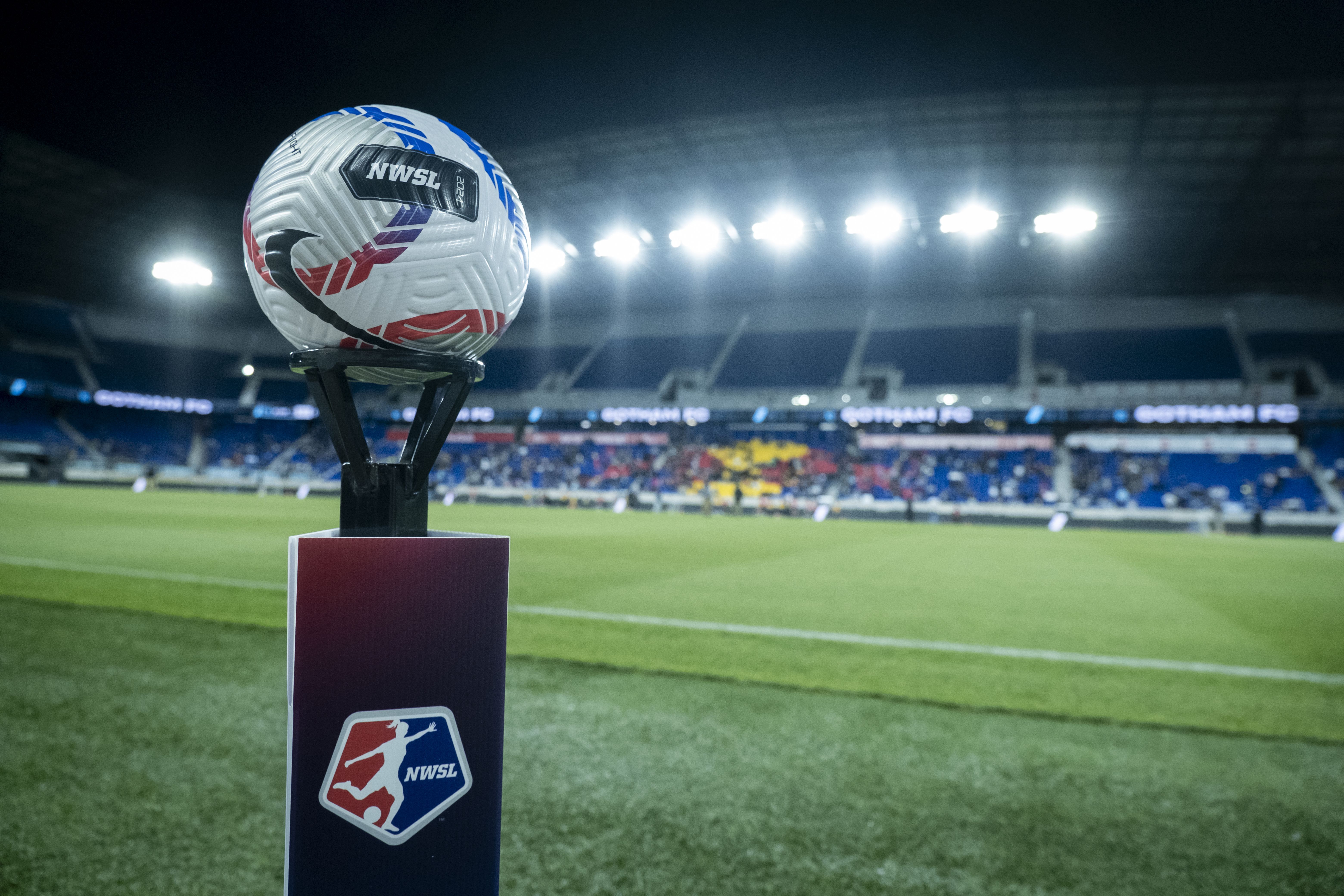official NWSL game ball sits on top of a pedestal with the NWSL Logo on it with the stadium behind the ball