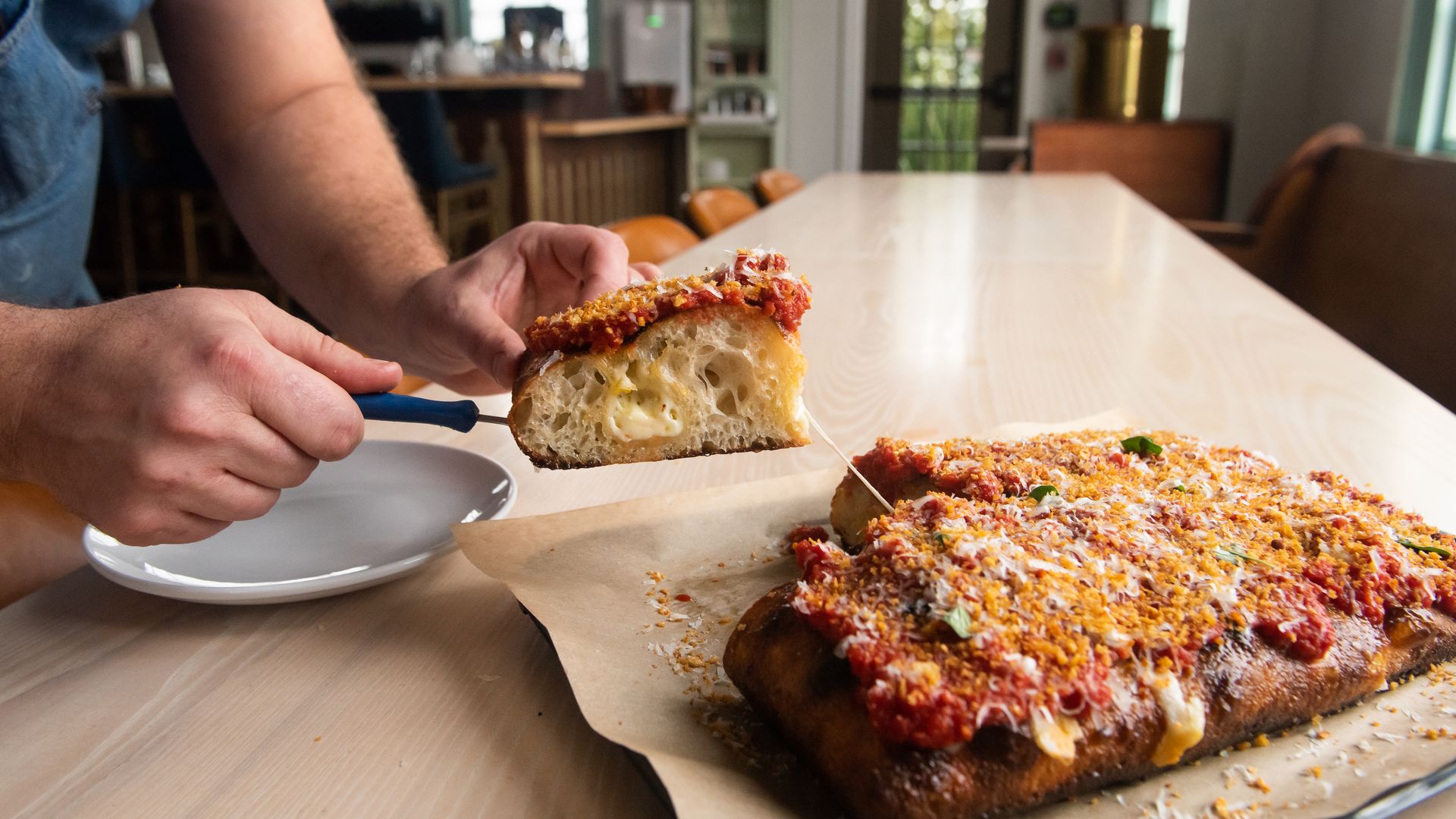 Someone cuts a slice of St. Vito pizza