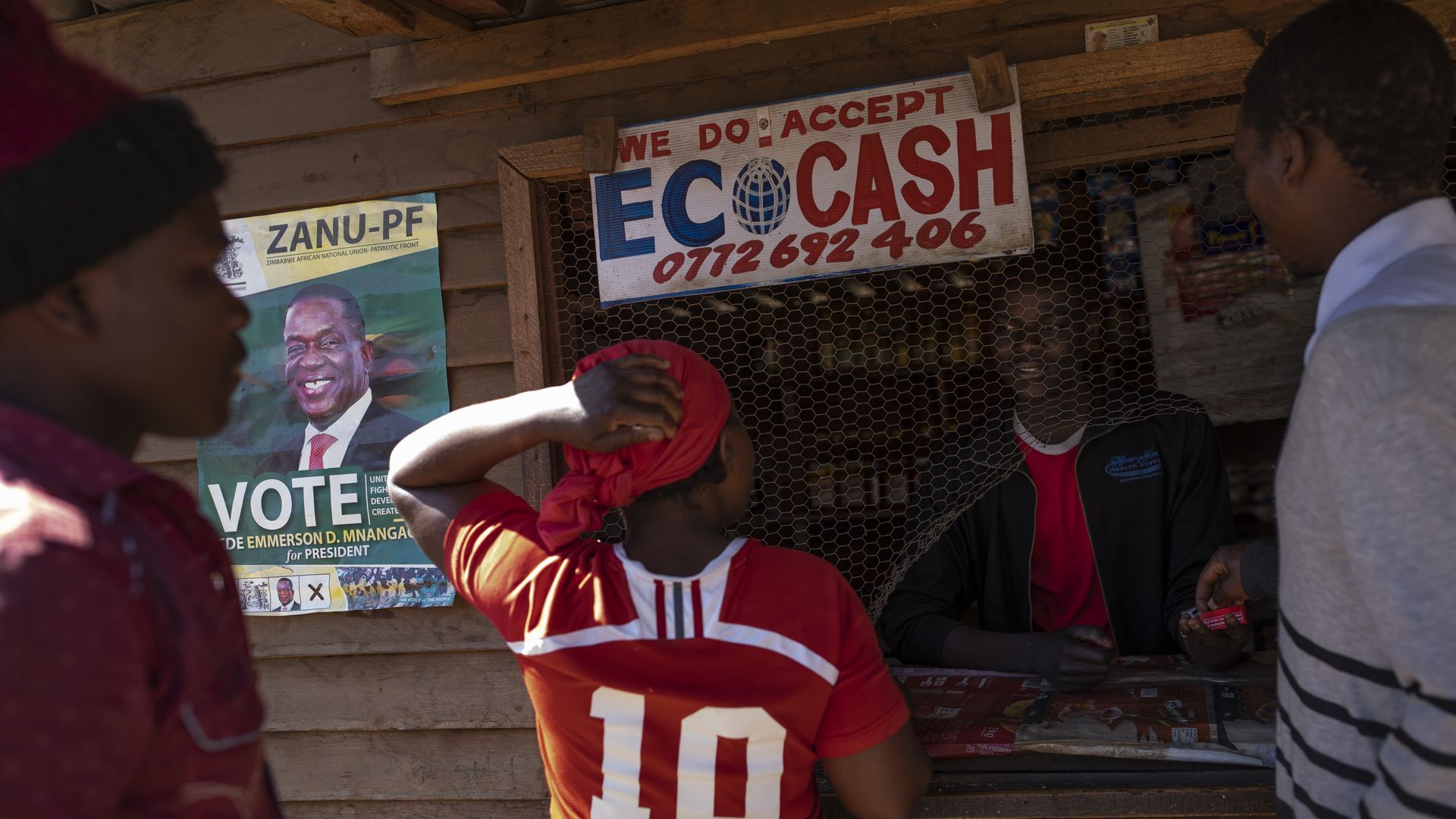 Vendors use a street shack that accepts EcoCash' to buy goods in the Mbare neighborhood on July 27, 2018 in Harare, Zimbabwe.