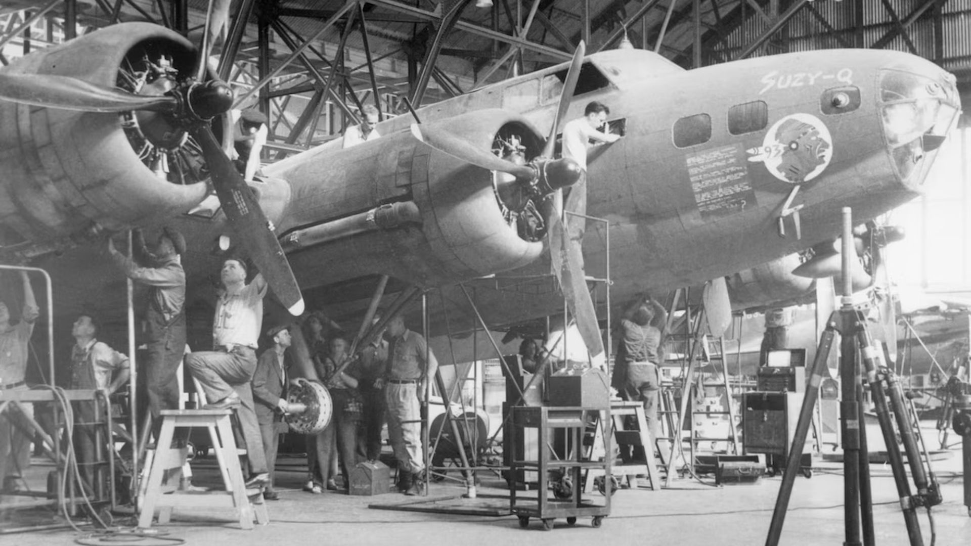 Crews work on a World War II airplane in an historical picture.