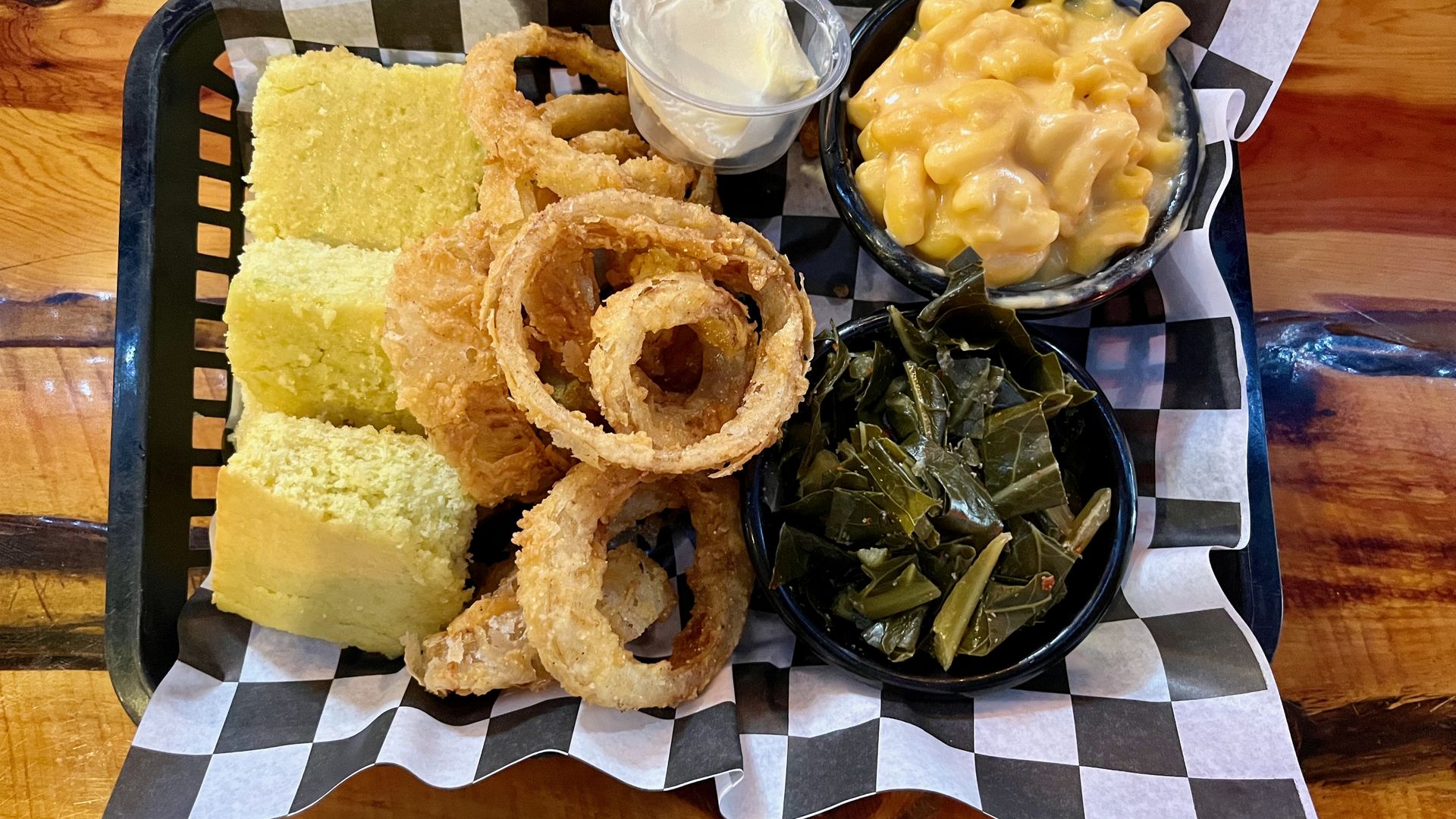 A basket of onion rings, mac and cheese and greens