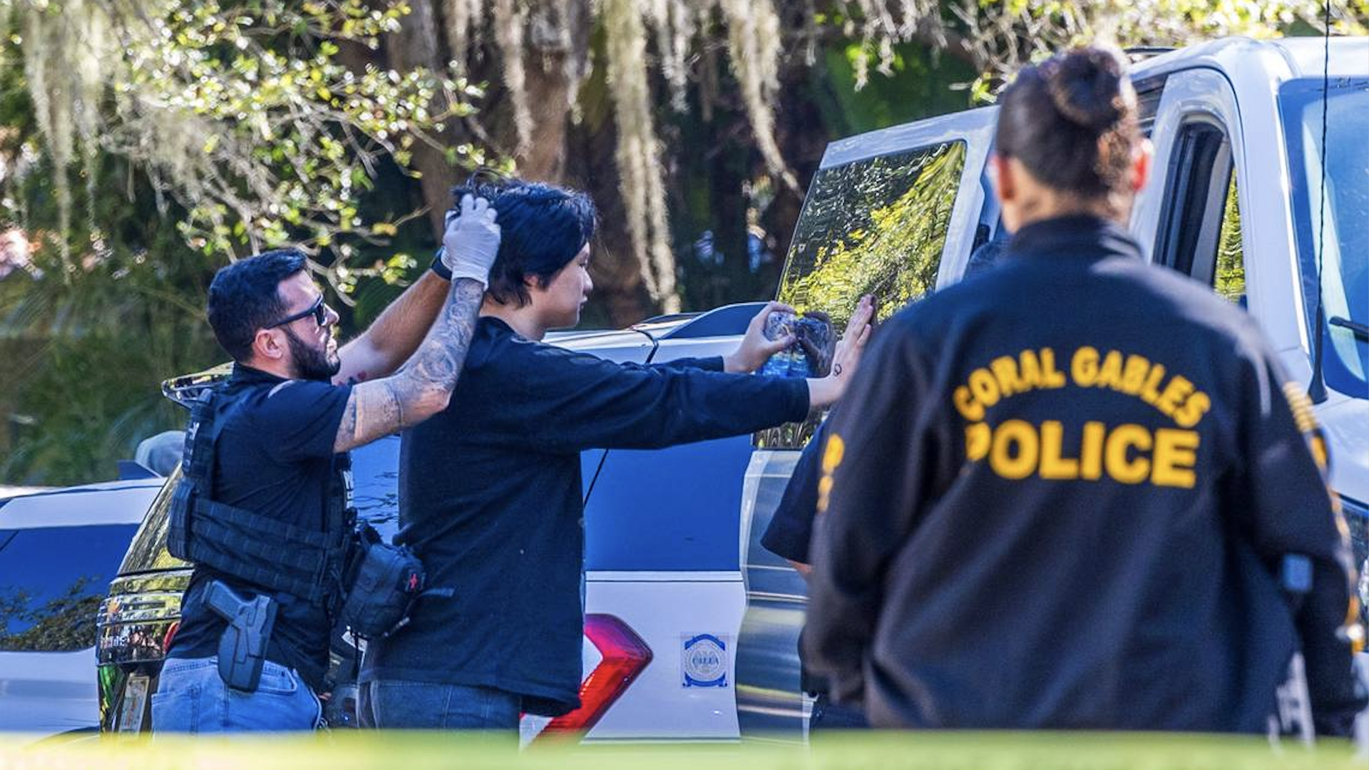 Multiple law enforcement officers in Florida detain a group of migrants suspected of being in the country illegally and two suspected smugglers in Coral Gables, Fla.