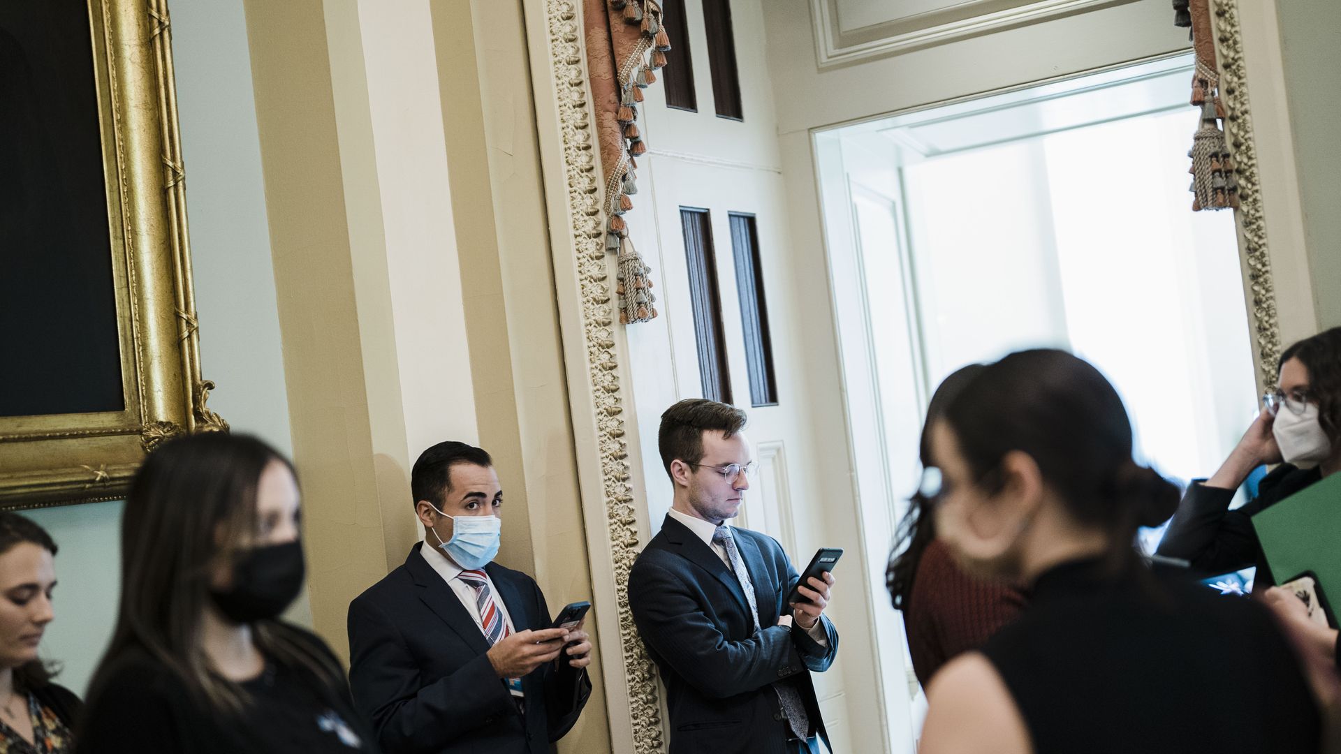 Hill staffers wait in a hallway. Photo: Kent Nishimura / Los Angeles Times via Getty Images