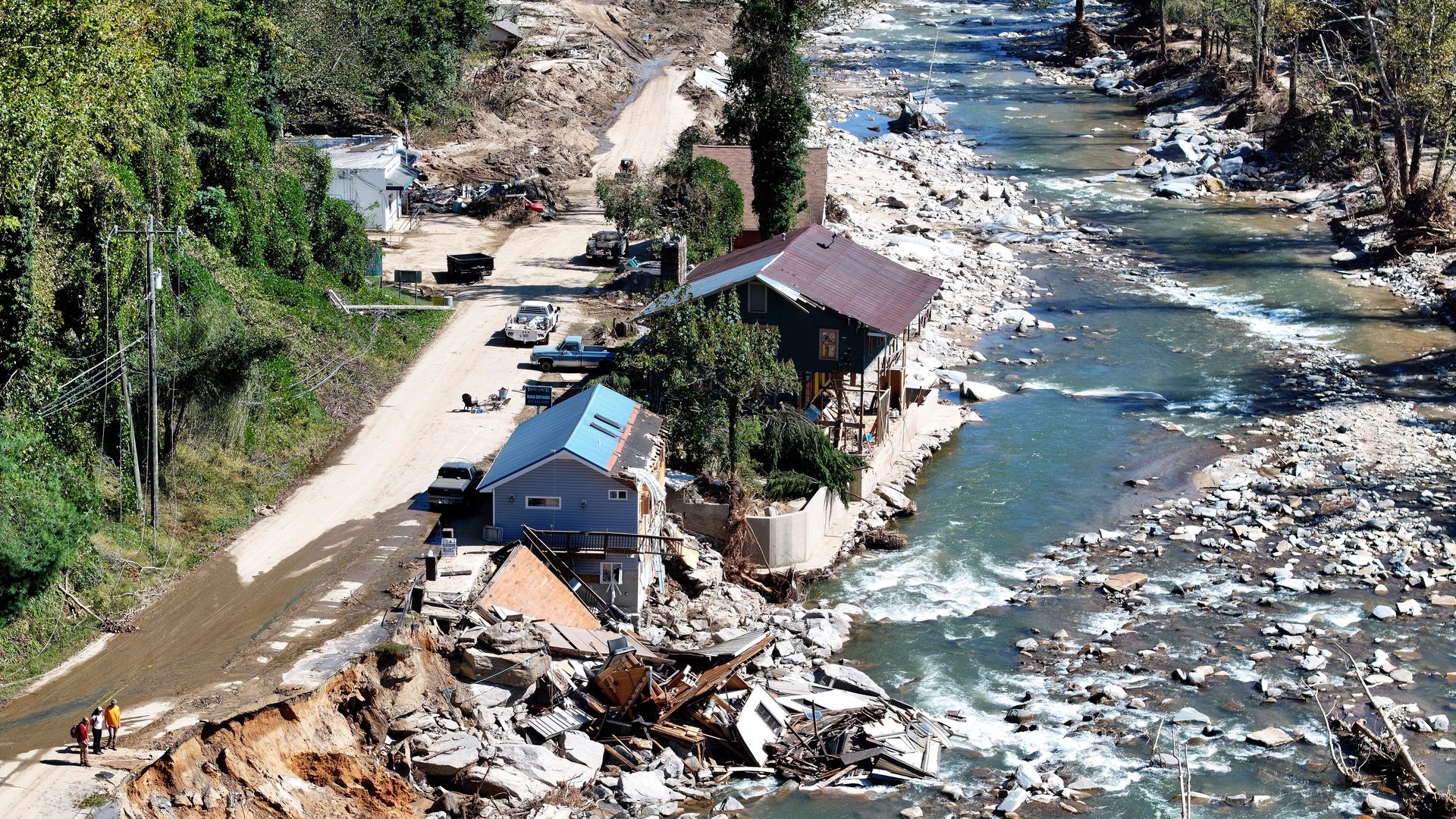 BAT CAVE, NORTH CAROLINA - OCTOBER 08: An aerial view of people standing near destroyed and damaged buildings in the aftermath of Hurricane Helene flooding on October 8, 2024 in Bat Cave, North Carolina. Bat Cave was particularly hard hit by flooding. Recovery efforts continue as the death toll has 