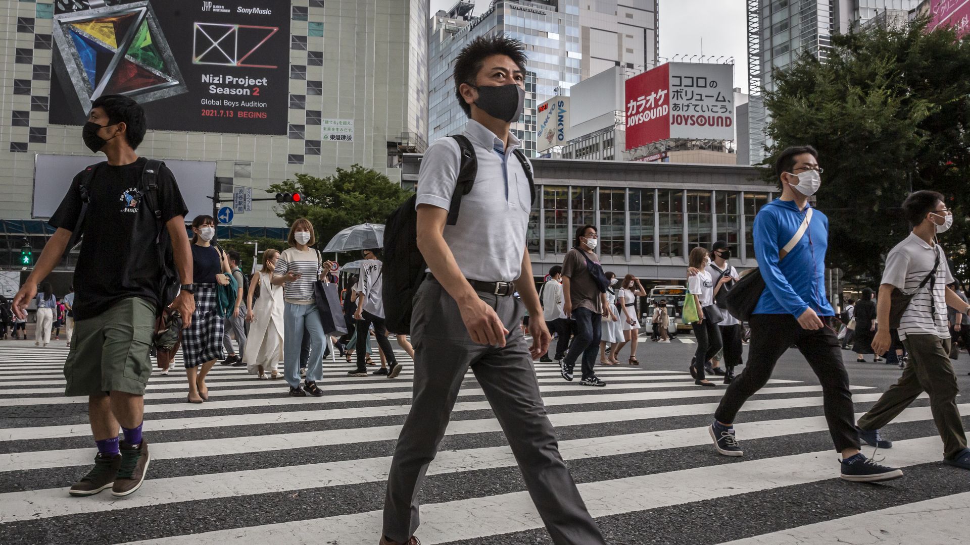 People wearing face masks cross Shibuya crossing on July 30, 2021 in Tokyo, Japan.